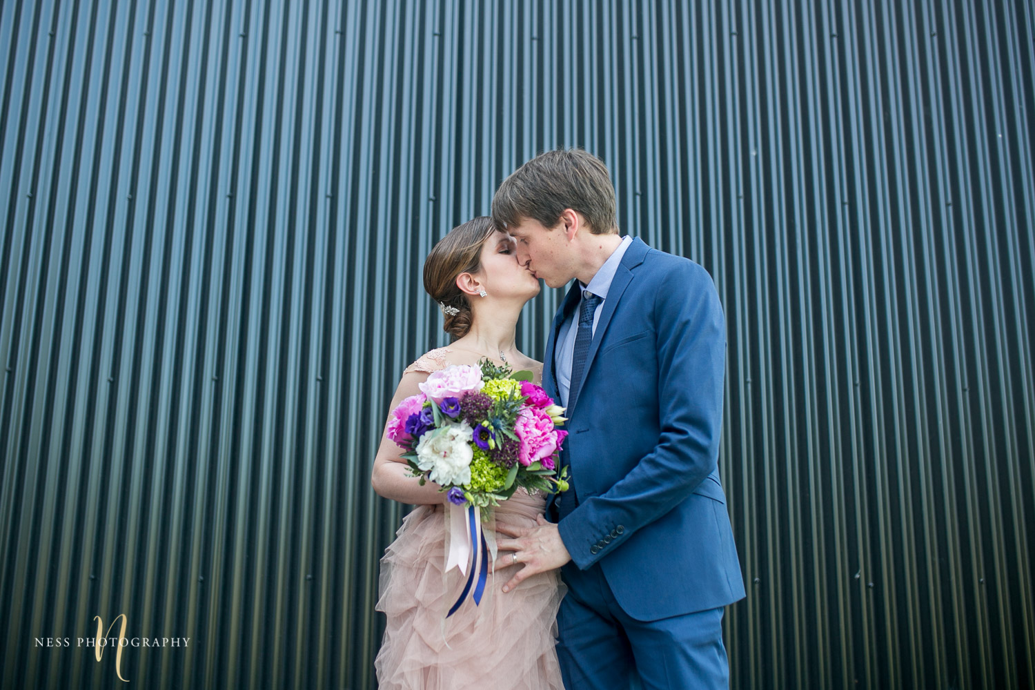 bride and groom kissing in front of shipping container in canal lachine for their montreal elopement 