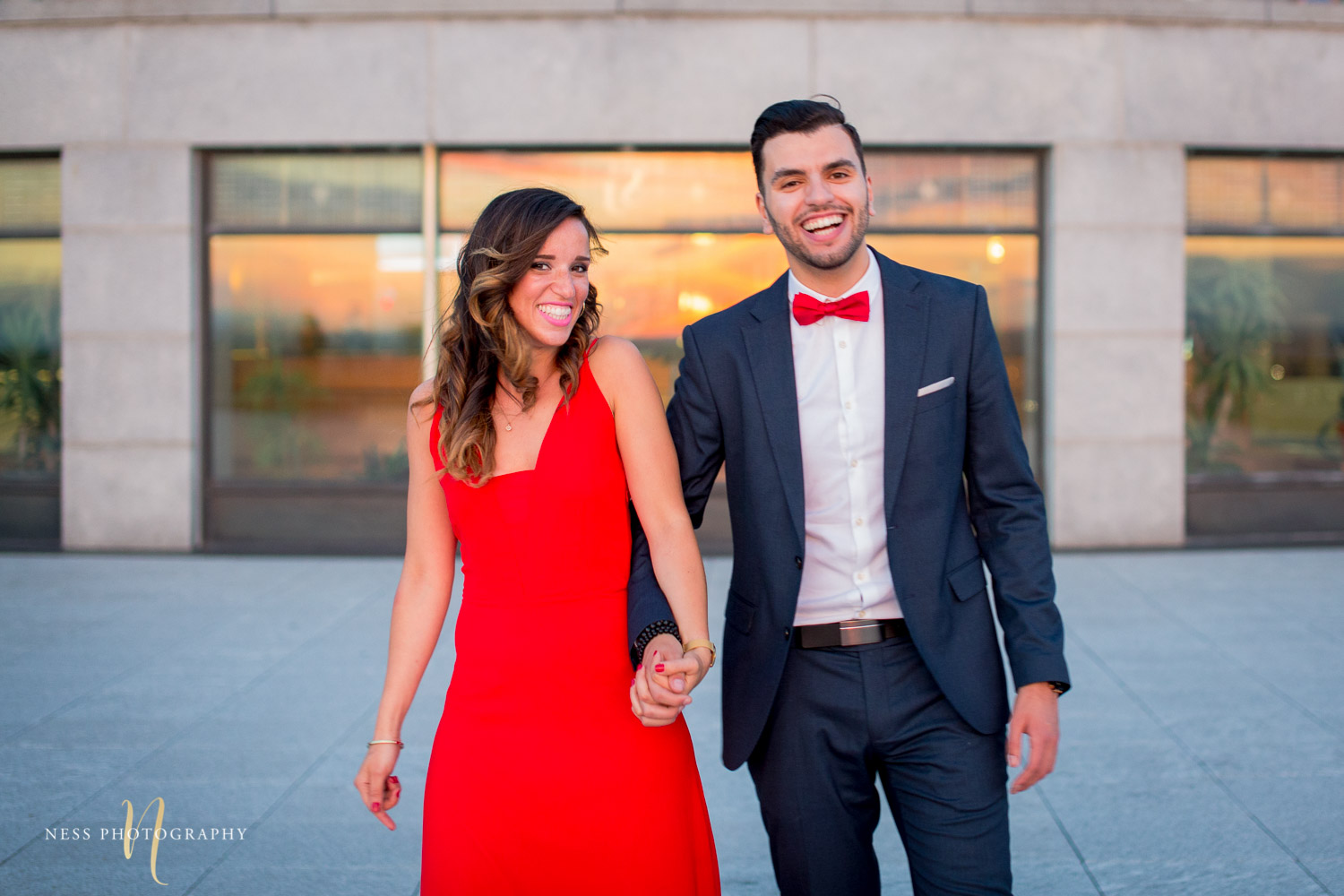 couple holding hands and laughing during montreal engagement session at oratoire saint joseph