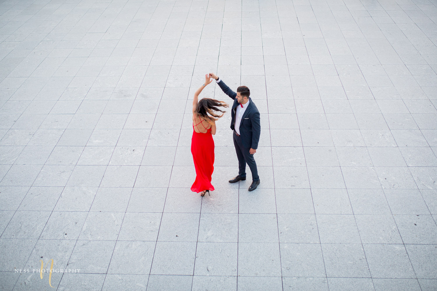 top down view of couple dancing during elegant engagement session in red dress with montreal wedding photograher