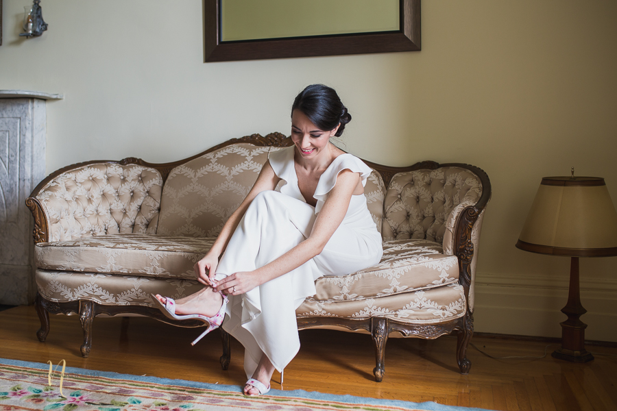 bride putting on her ted baker floral shoes at Wedding at Forest and Stream club by Ness Photography