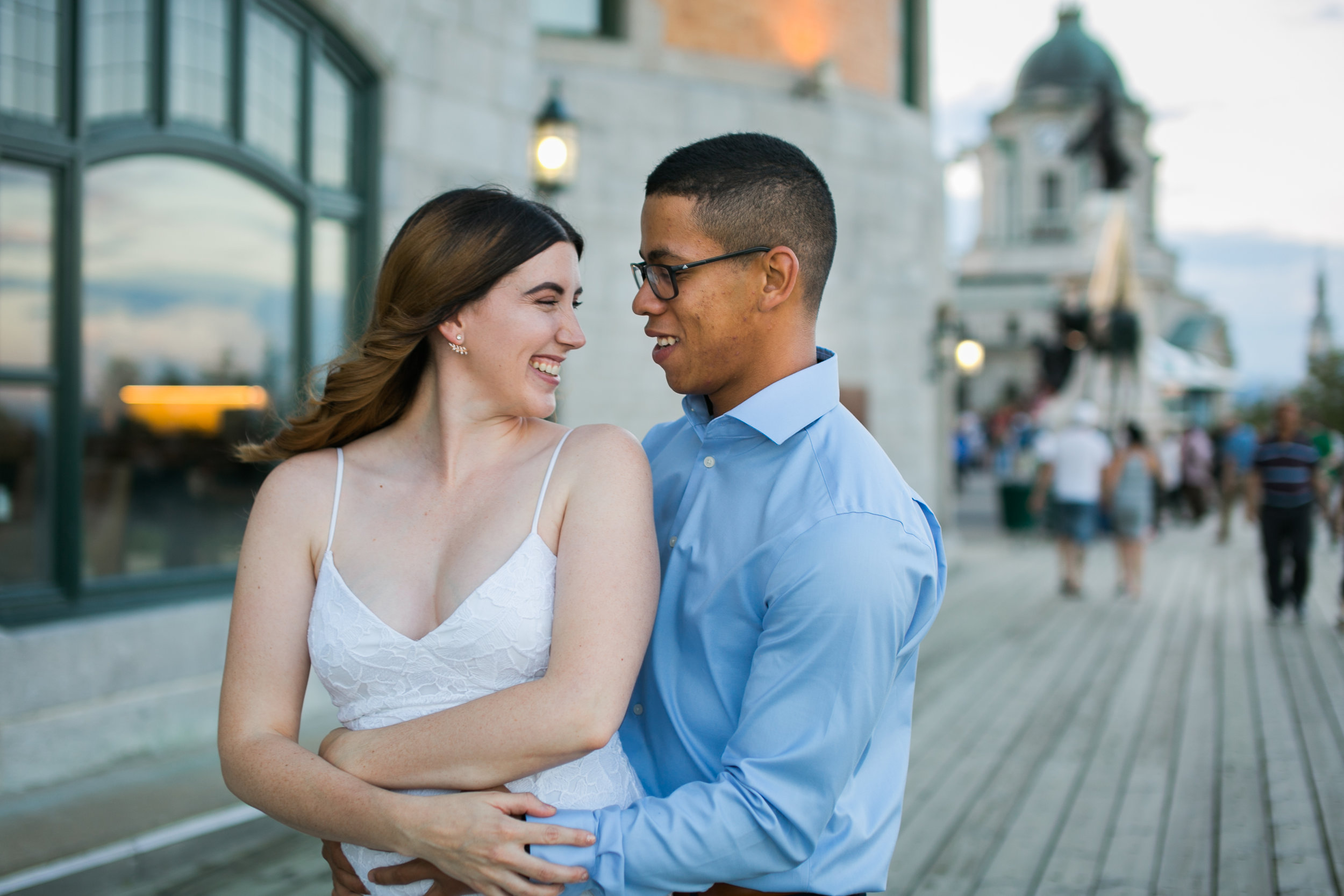 couple hugging and smiling in front of chateau frontenac