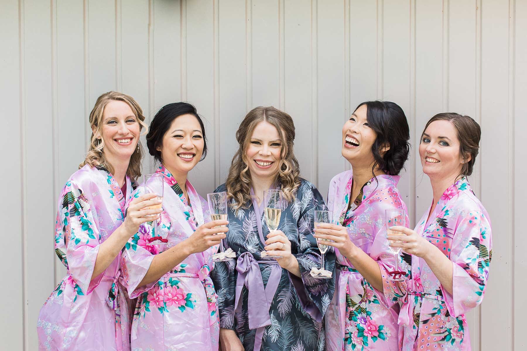 bridesmaids in pink kimonos toasting champagne at pointe claire yacht club wedding