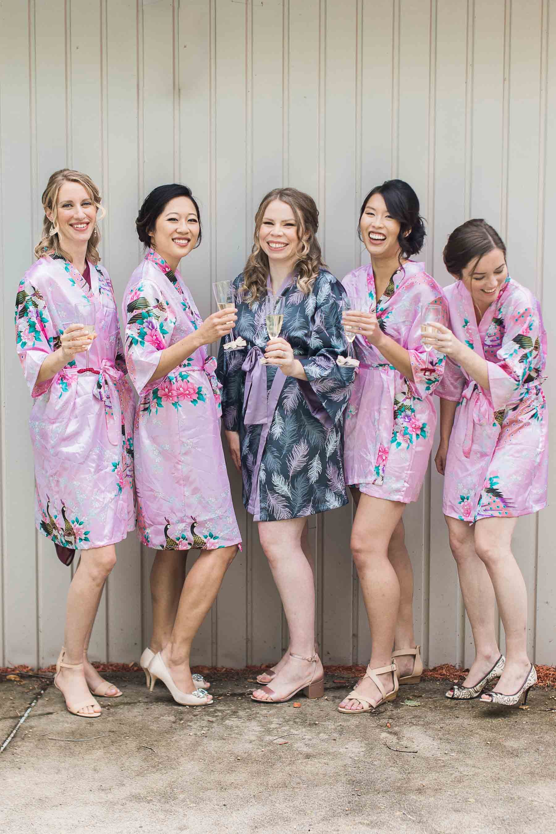 bridesmaids in pink kimonos toasting champagne at pointe claire yacht club wedding