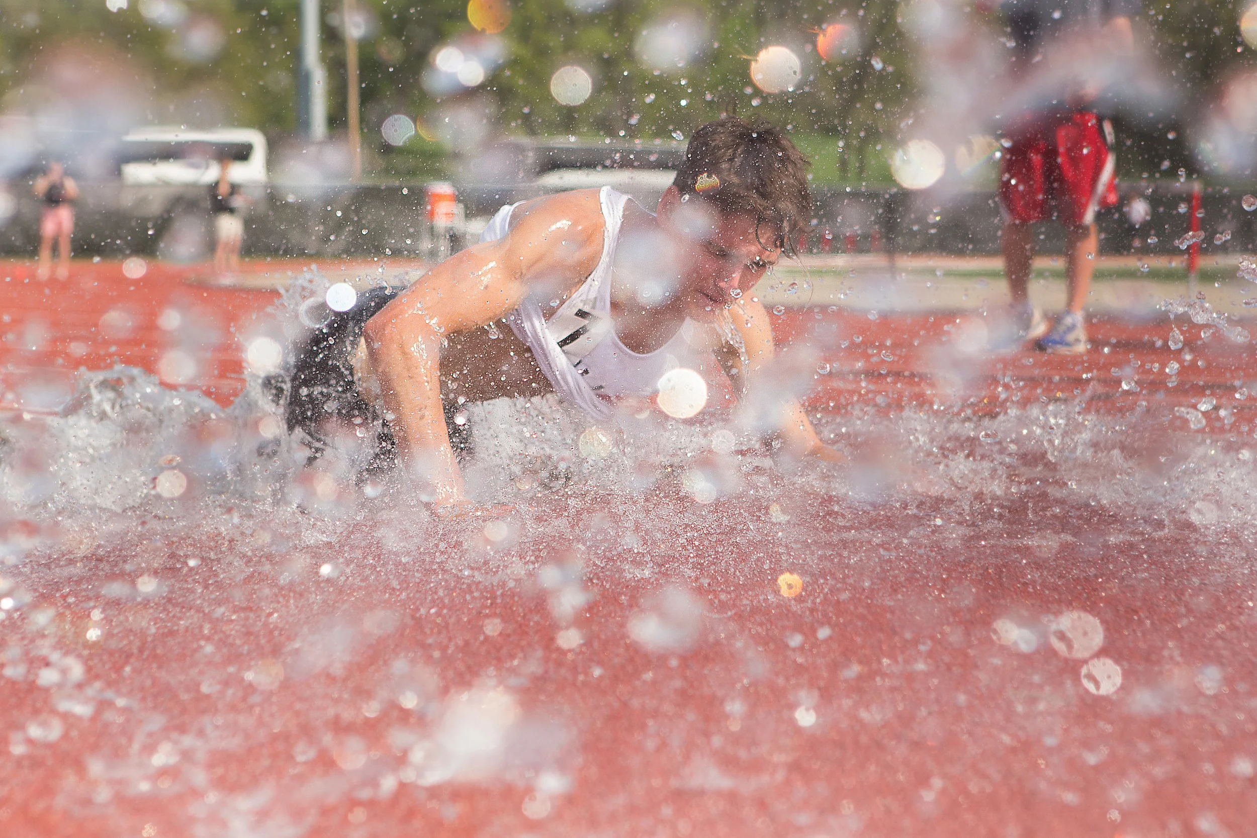  Freshman Ben Scamihorn of Marshall, Ill. falls into the water pit while competing in the steeplechase at the SIUE Gateway Invite on Apr. 18 2015. 