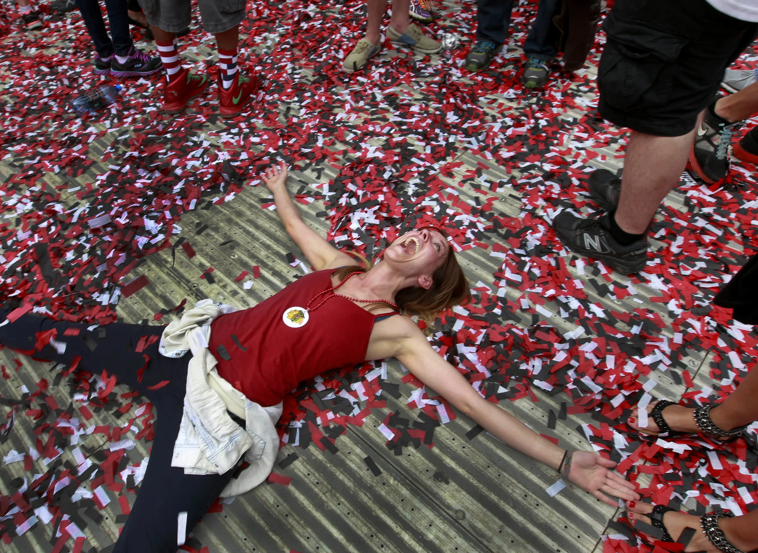  Chicago Blackhawks fan Holly Frolek creates a confetti angel as she celebrates during a rally for the NHL hockey club's Stanley Cup championship at Soldier Field, Thursday, June 18, 2015, in Chicago. (AP Photo/Christian K. Lee) 