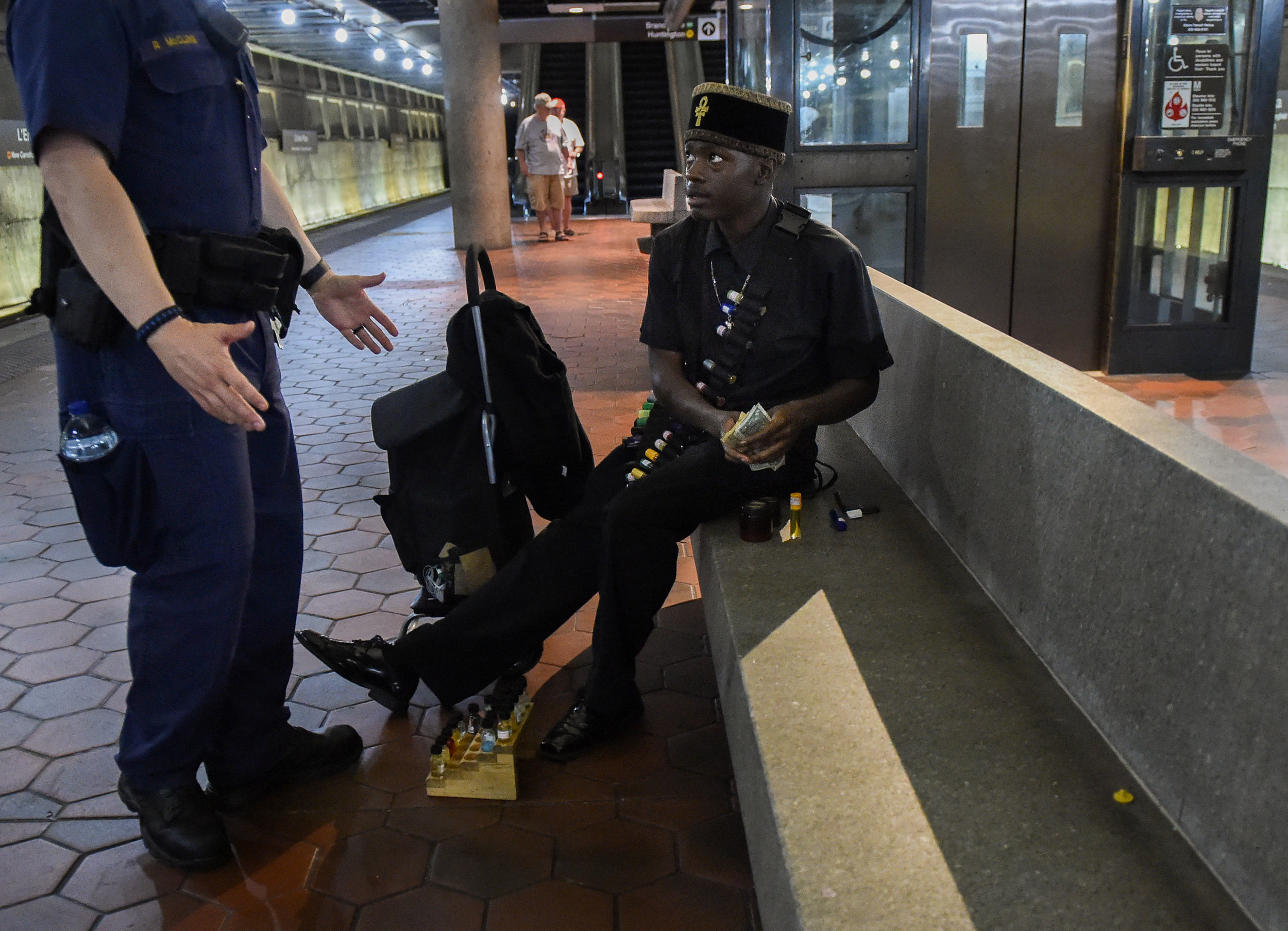  A metro train officer stops Millden as he counts the money he has made that day Saturday, June 11, 2016. He does not own a solicitation license and he is often stopped by law enforcement. "I would get one but thats money I could use to eat that day," Millden said. 