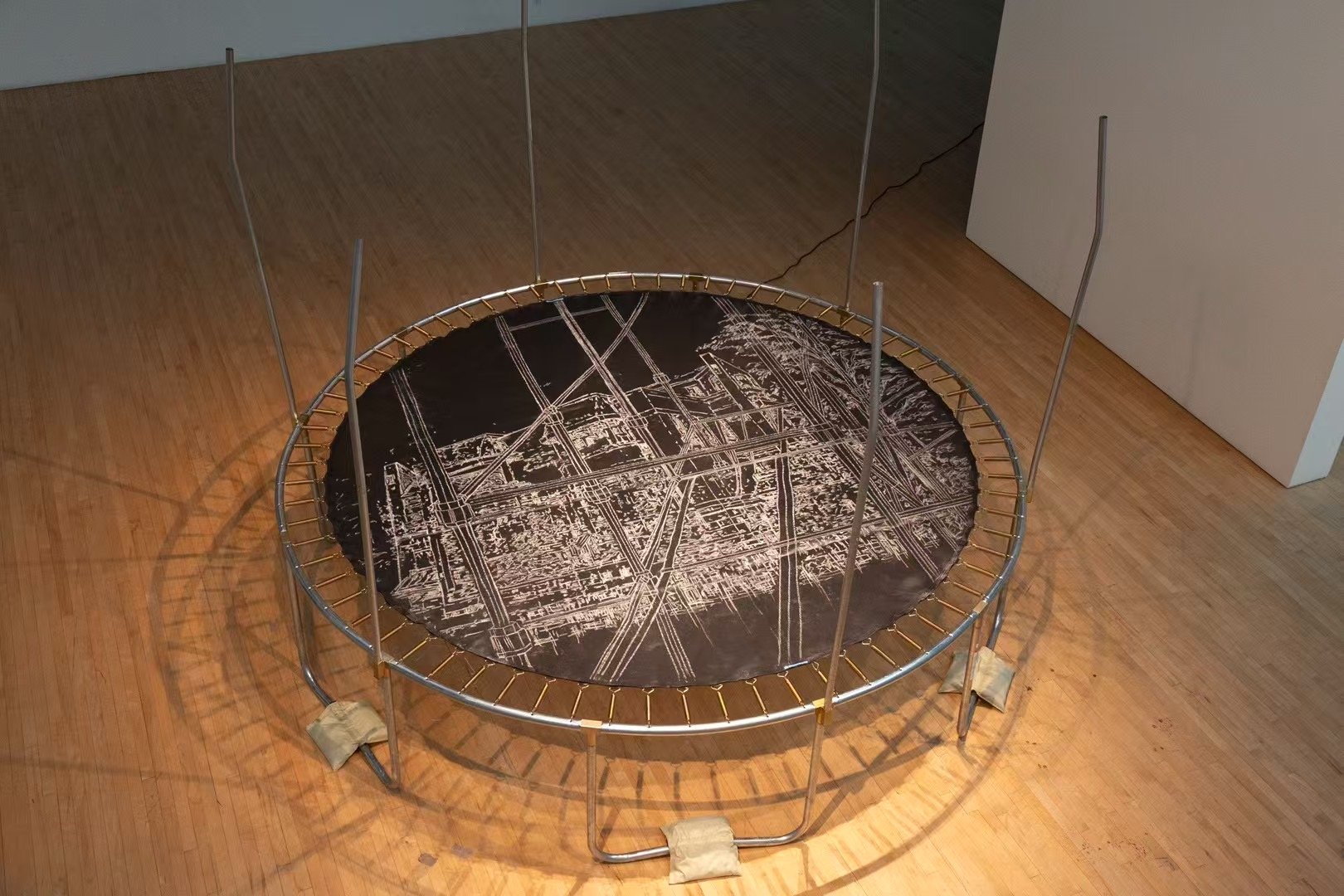  A trampoline becomes the platform for a living drawing, where a large chalk piece is layered over original architectural renderings from Xie's grandfather—blueprints from the 1960s. 