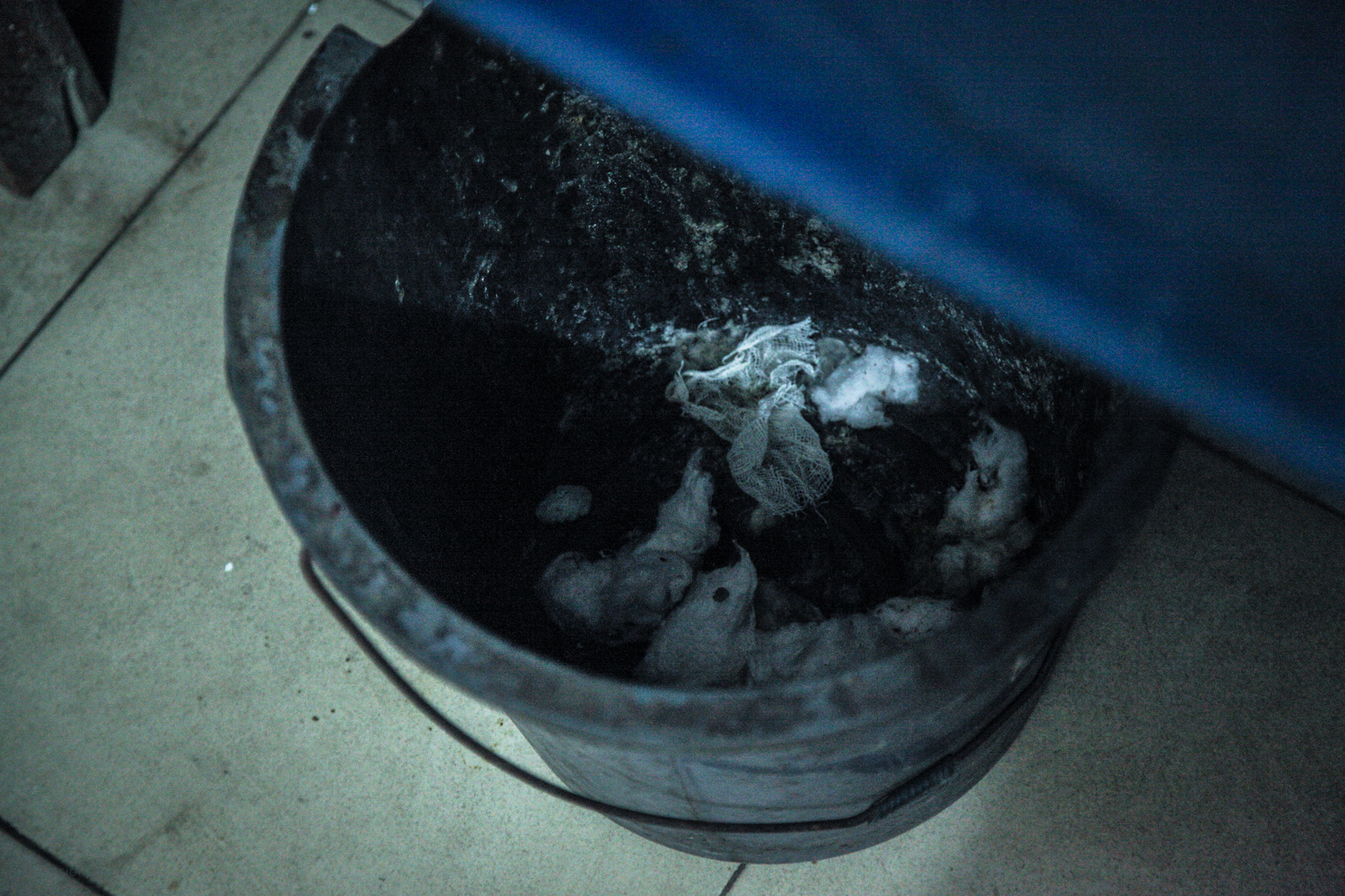  One of the medical waste bins under the examination table 