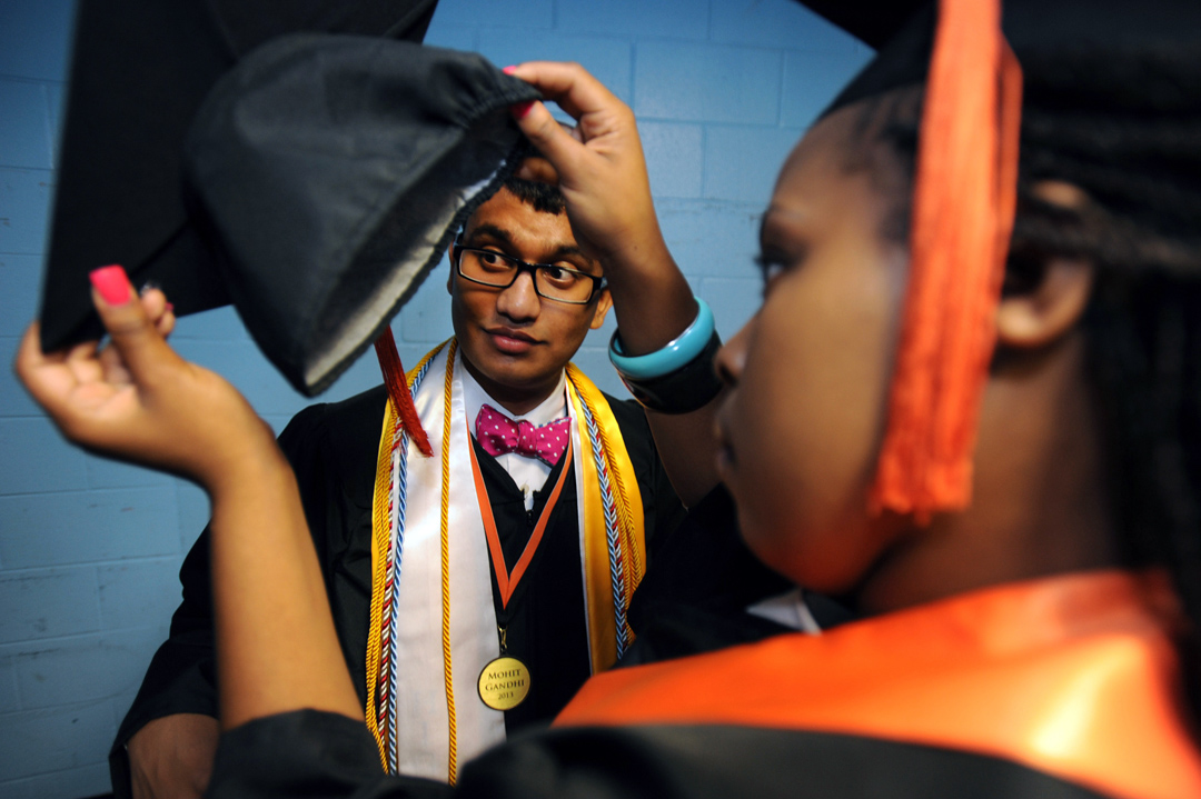 Tamera Fowler, right, helps Mohit Gandhi, left, with his cap before the start of Southside High's graduation ceremony.