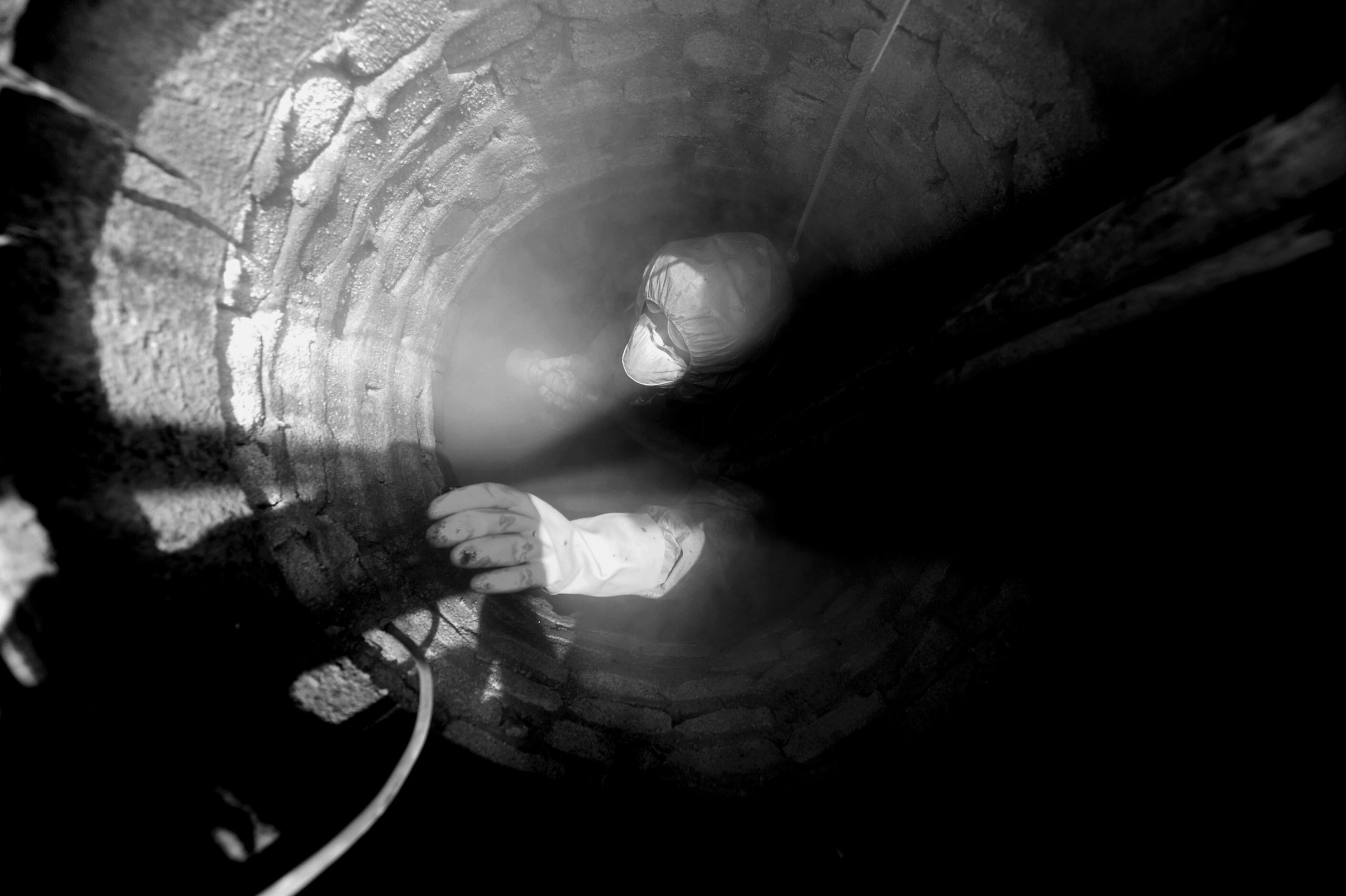 Randy Deaton of the City of Greenville goes into a manhole at the intersection of Wedgewood and Broughton drives to line the interior with cement. (June 7, 2011)
