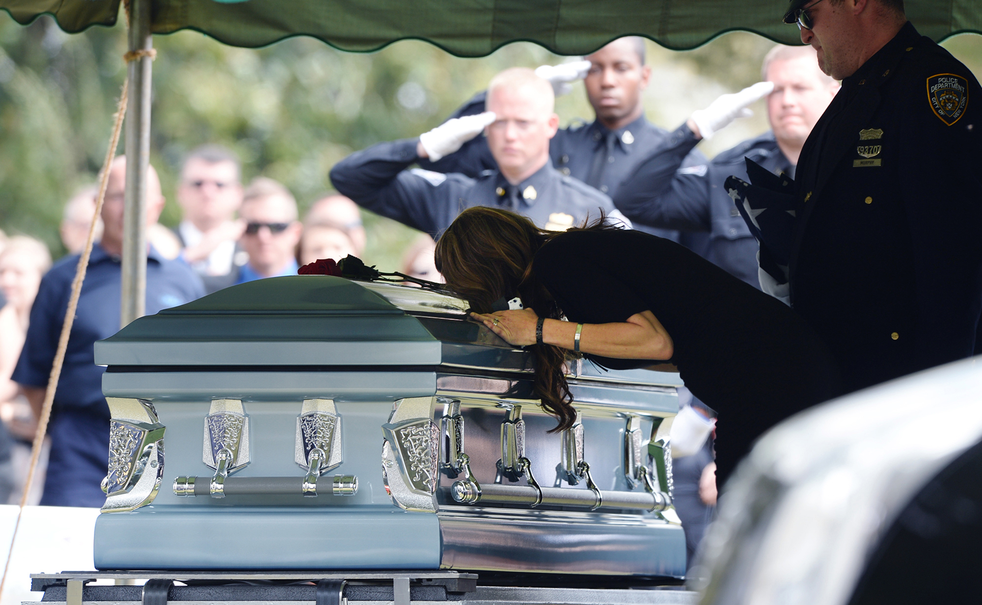  The wife of Greenville City Police Officer Allen Jacobs leans over his casket at the graveside service at Coleman Memorial Cemetery in Travelers Rest. 