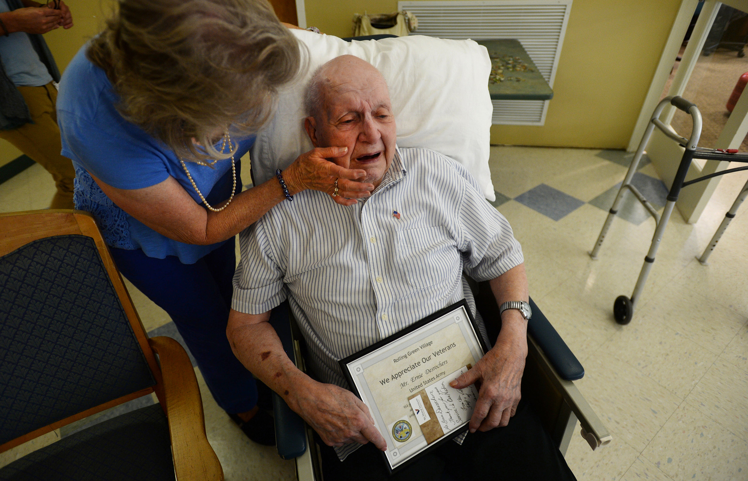  Carol Cole, left, congratulates her friend and Army veteran Ernie Desrochers after he received a certificate of appreciation and an American flag pin from Lutheran Hospice at Rolling Green Village on Tuesday. 