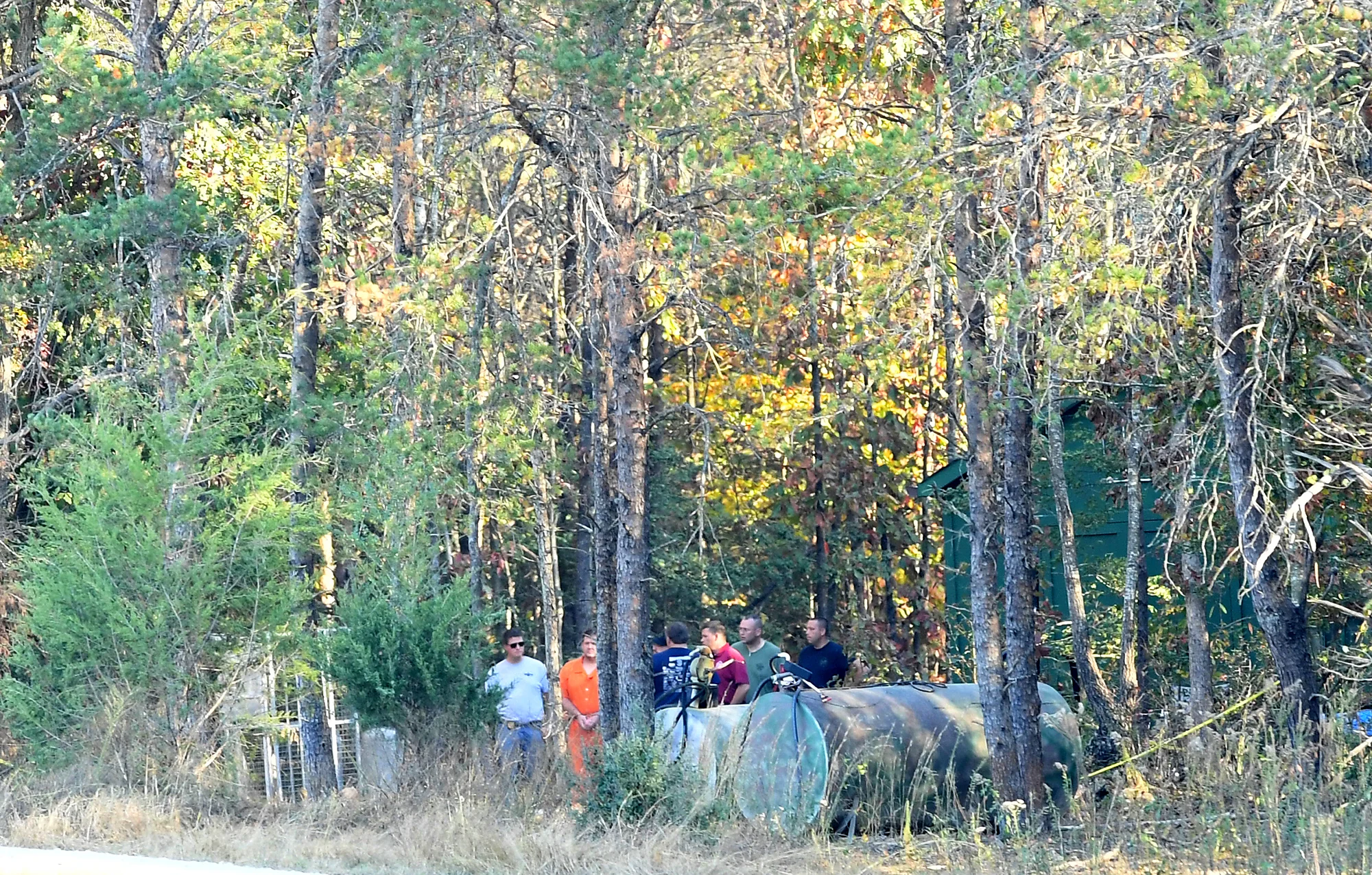 Todd Kohlhepp in handcuffs and an orange jumpsuit walks with deputies Saturday, November 5, 2016, on the property where a missing woman was found chained in a metal container in Woodruff.