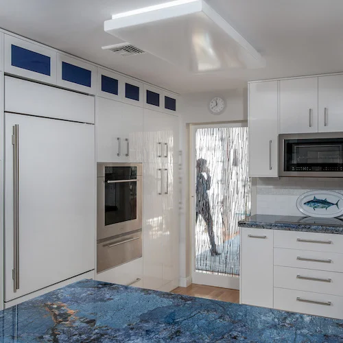 KitchenVisions_Manmade cabinetry painted white blue glass_Brookline.jpg