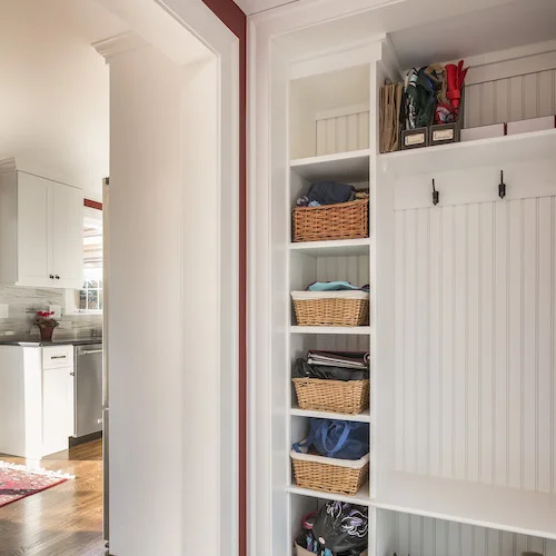 A New Traditional mudroom in Needham features Beadboard and layered moldings.