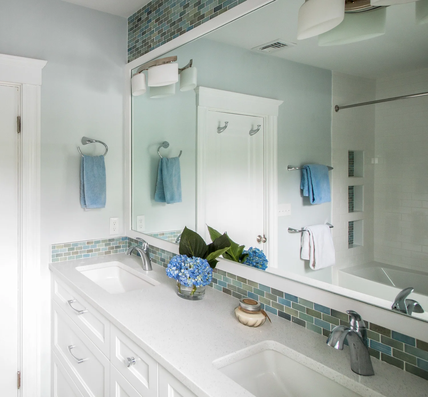 Family Bath After - reflection in mirror of bathtub/shower shared wall