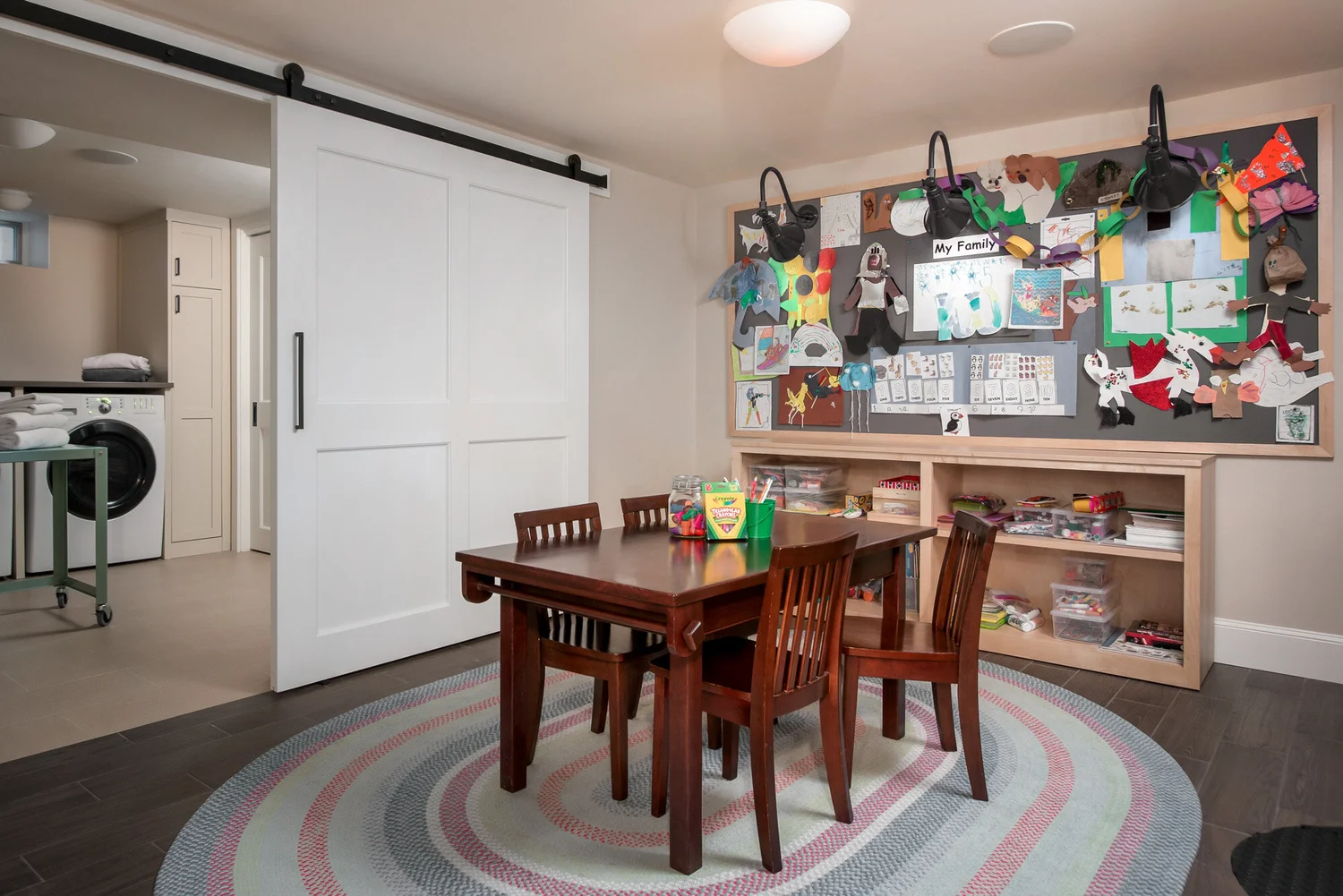 Newton basement with large laundry room and homeschooling or playroom, plus workout area and relaxation area with a TV. Builder: Jensenhus  Photography: Michael Lefebvre