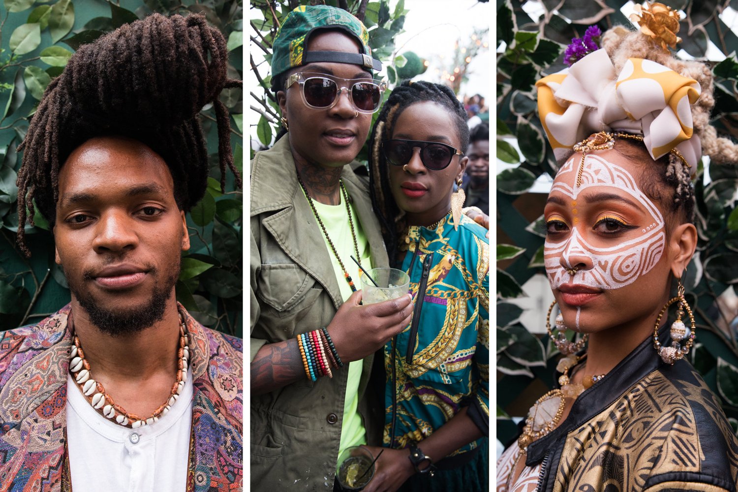 Three people at a cultural event. The first is a man with dreadlocks wearing a patterned jacket and shell necklace. The second is a woman with glasses and tattoos, holding a drink, wearing a green cap, sunglasses, and a beige jacket. The third is a woman with face paint, jewelry, and a large decorative head wrap, standing among greenery.