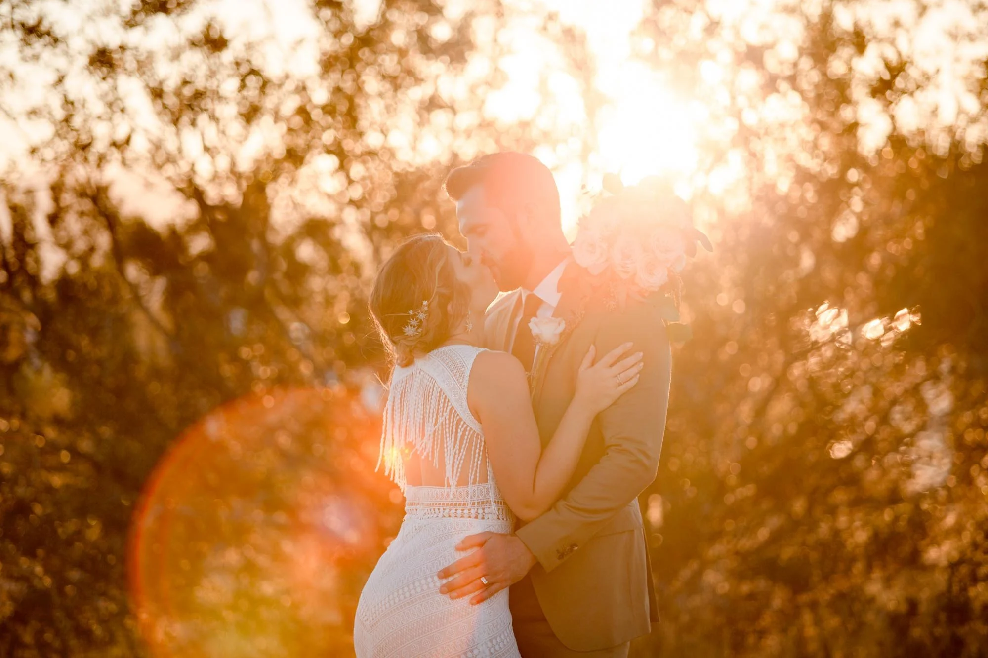 Couple embracing in the desert with golden sun flare in Joshua Tree CA (Copy)