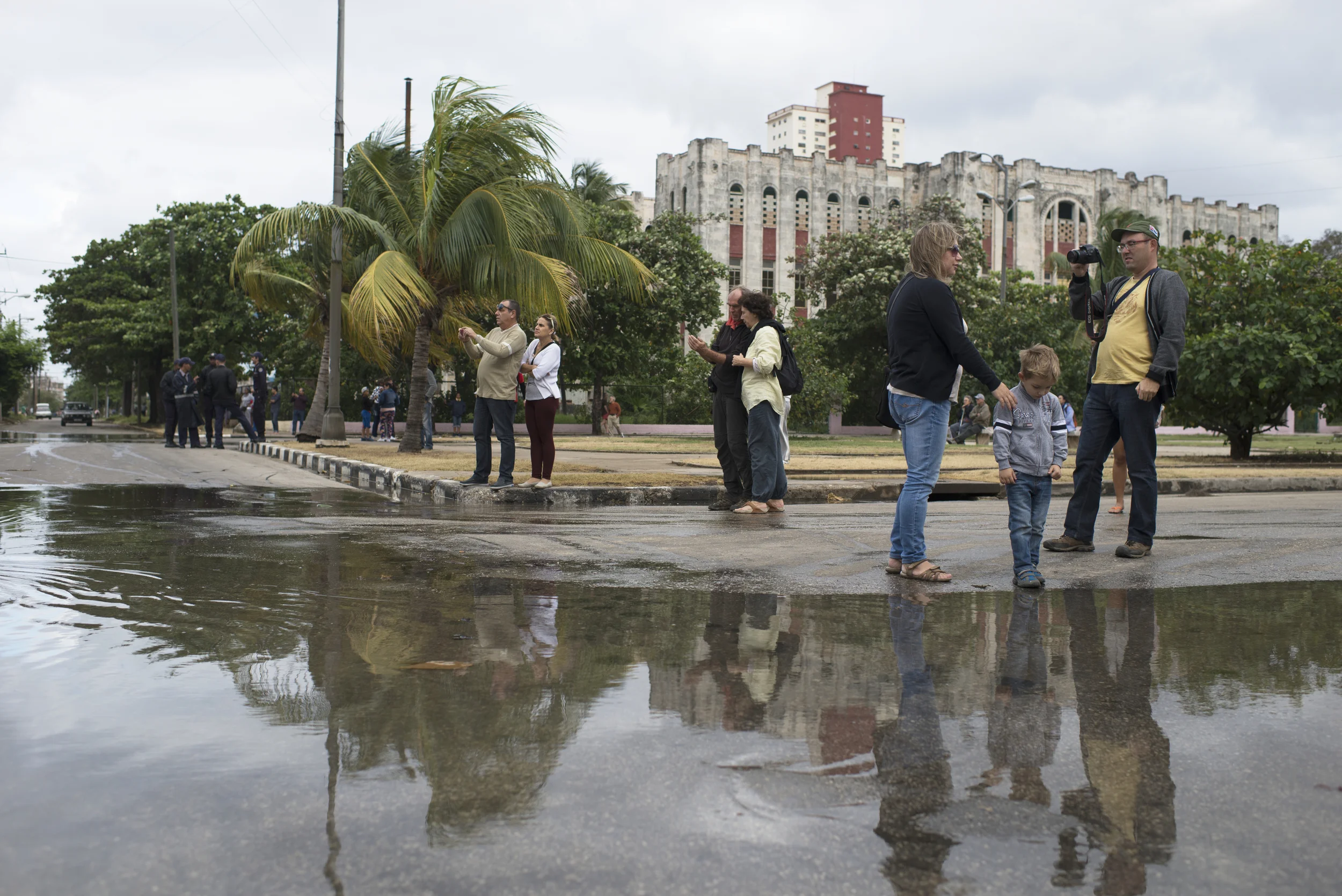 A family stands next to the flood waters in Havana, Cuba on Jan. 23, 2016. 