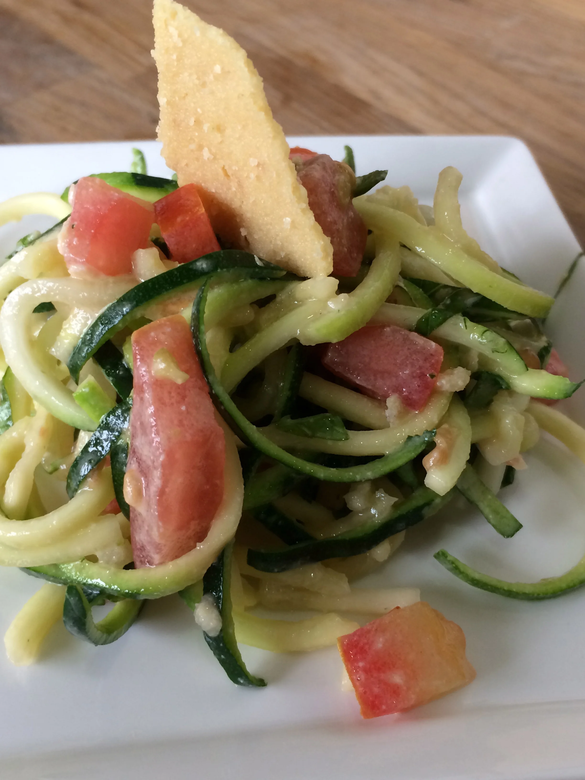 Spirilized zuchini with tomatoes, olives, and basil with seed based cheese