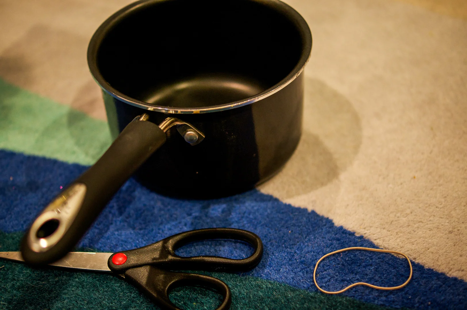 A pair of scissors Some light colored rubber bands A pot or deep pan
