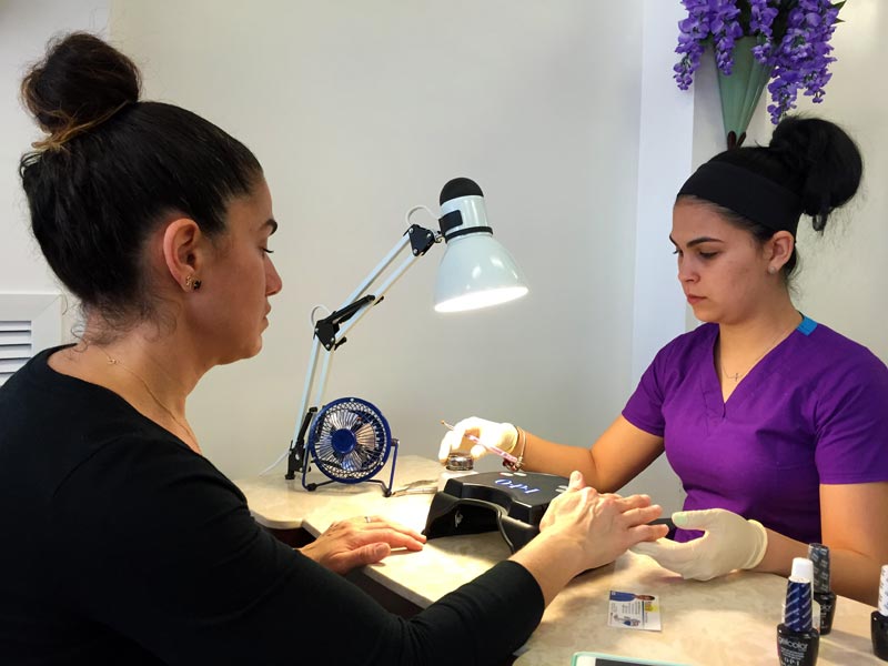 New customer Araceli Rodriguez receives manicure from Diane Silva