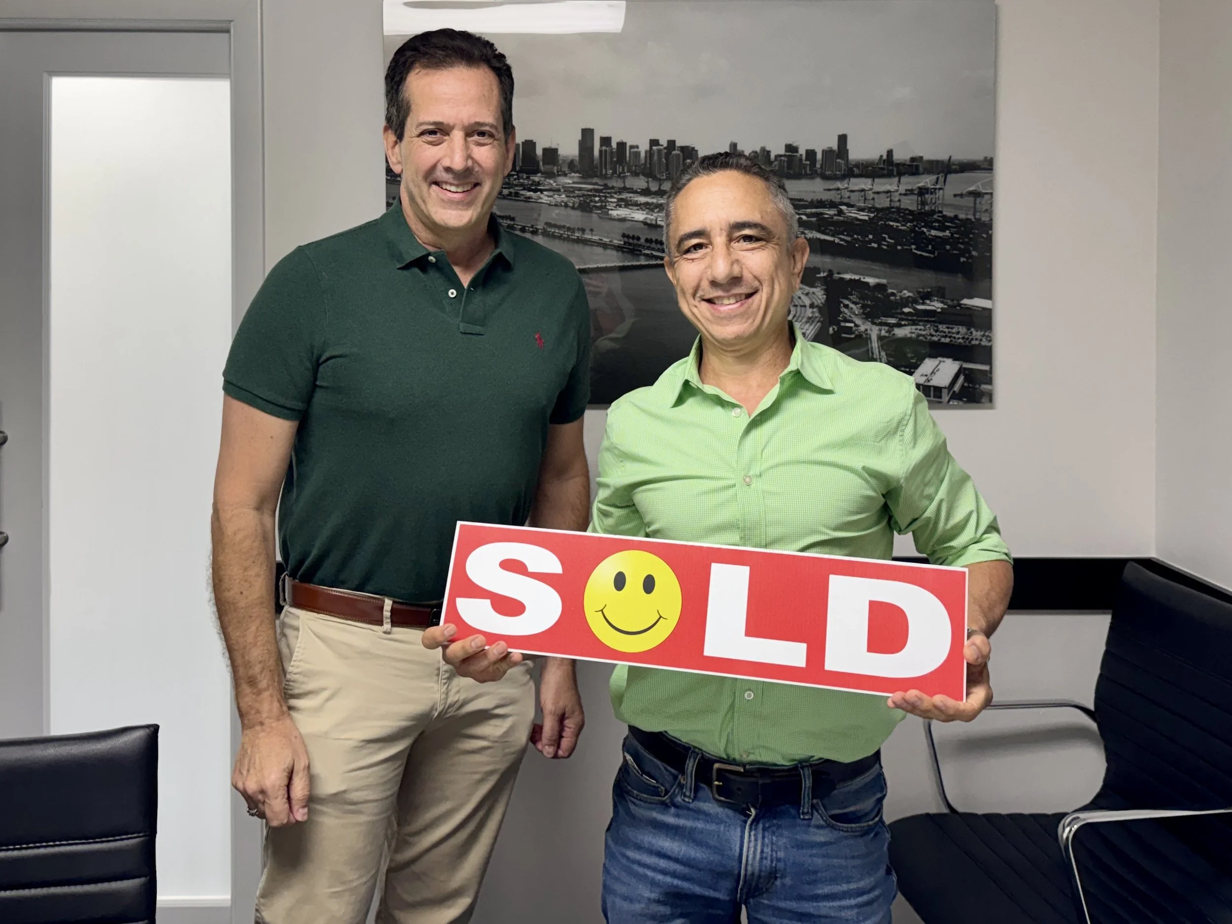 Marco and Hal standing with SOLD sign in hand