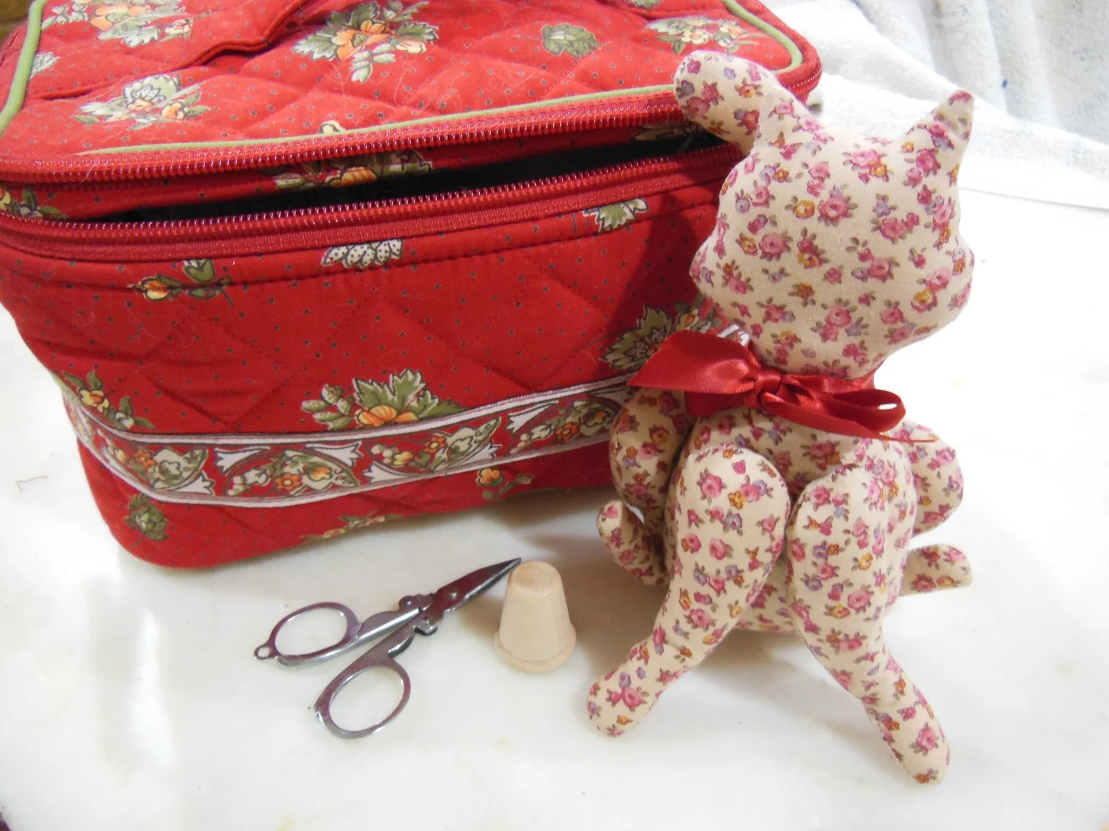 red quilted bag with cat pincushion