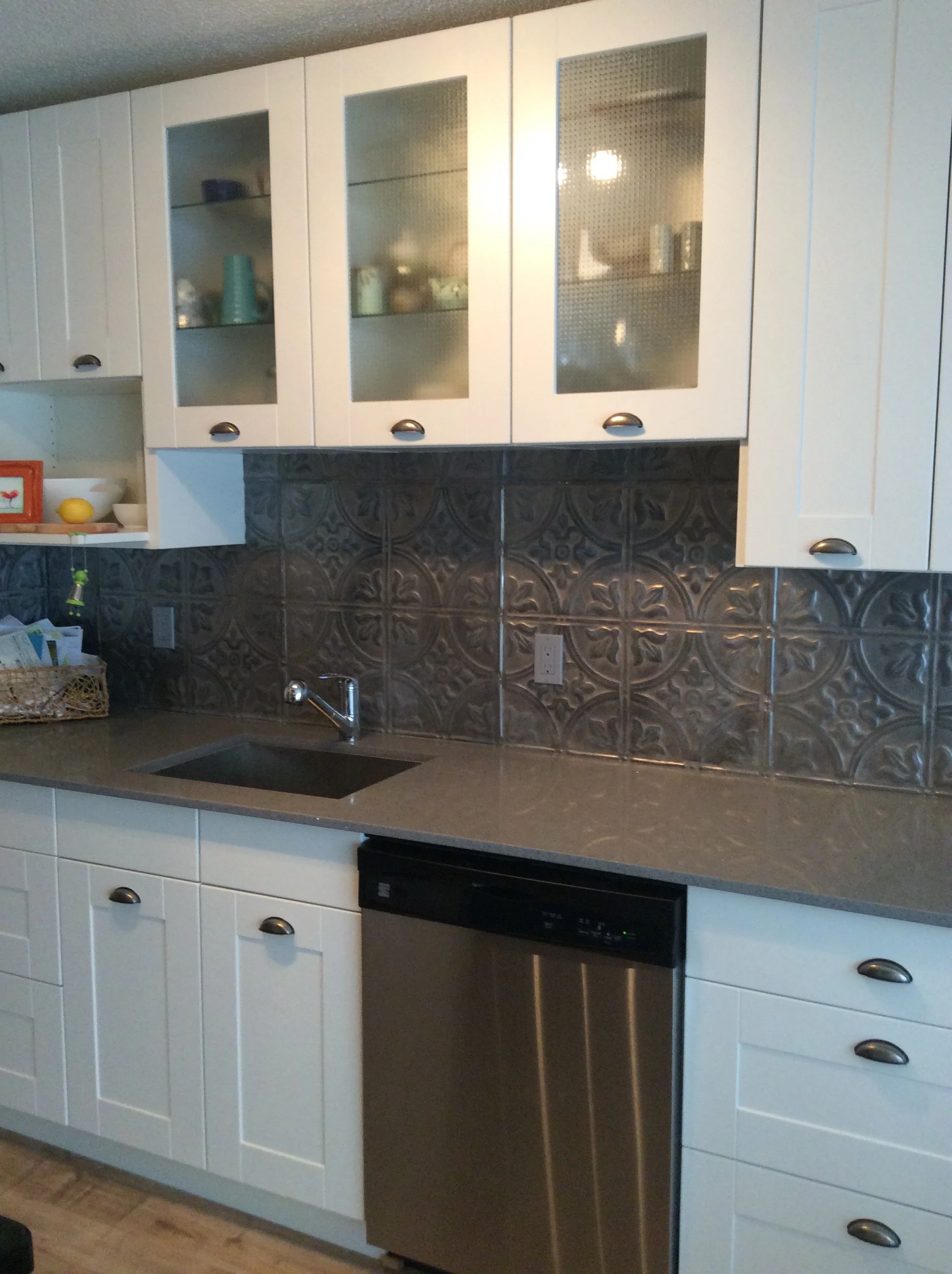 Ikea kitchen, quartz countertop, tin tile backsplash. 