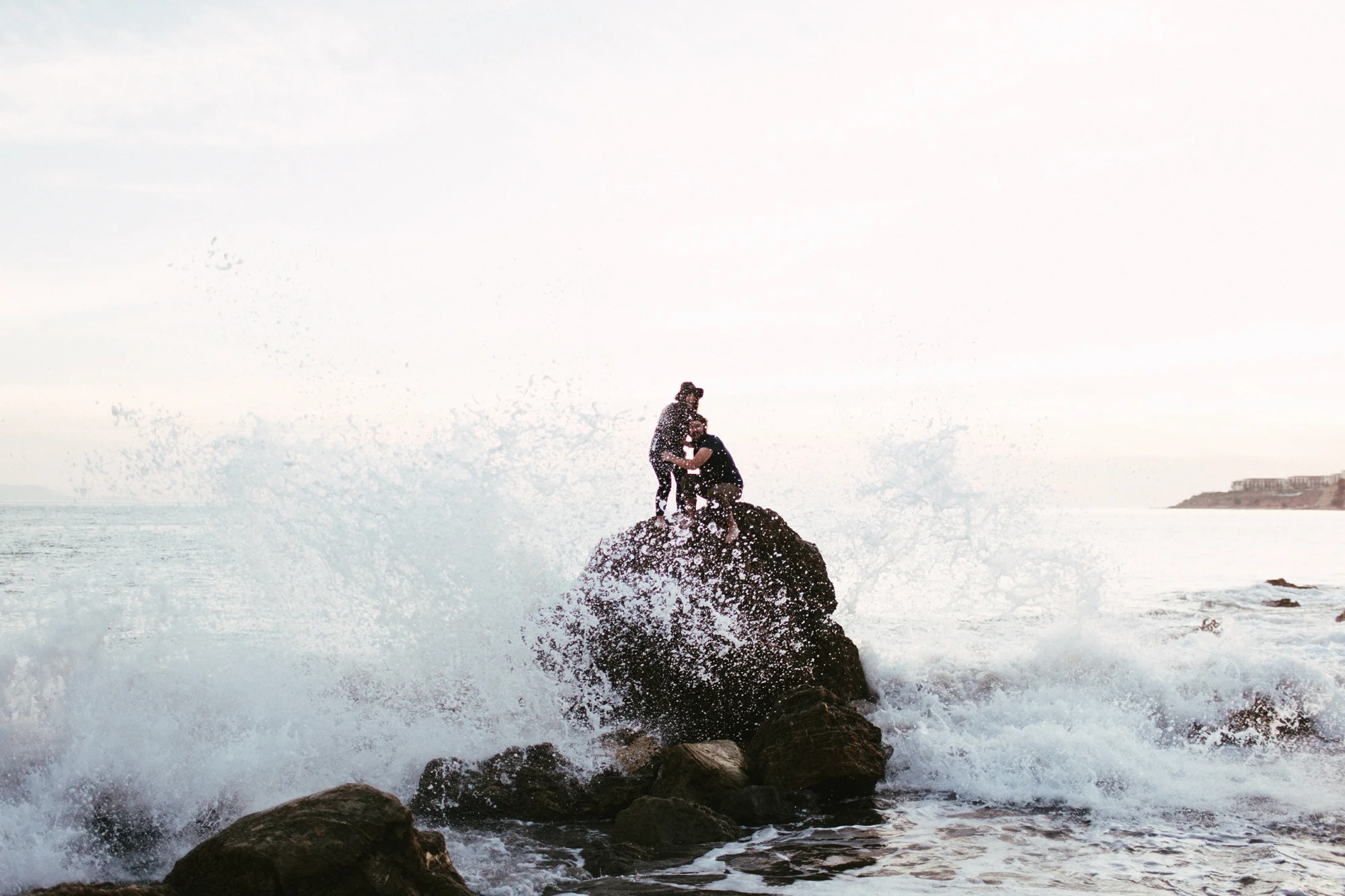 amazing couple on rock in ocean