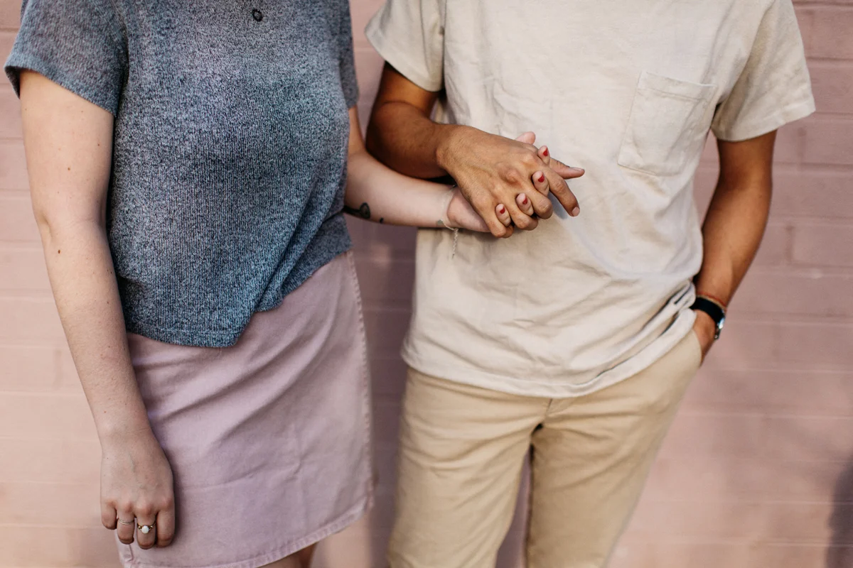 pink wall cute couple holding hands
