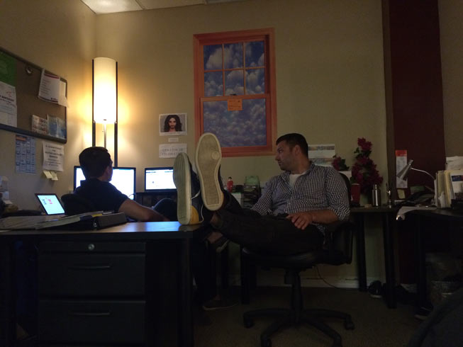 Tom and Justin (shoes up) in "The Grotto." My desk was where Justin is sitting with the fake bougainvillea.