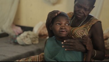 A girl with nodding disease, sitting with her mother at the hospital