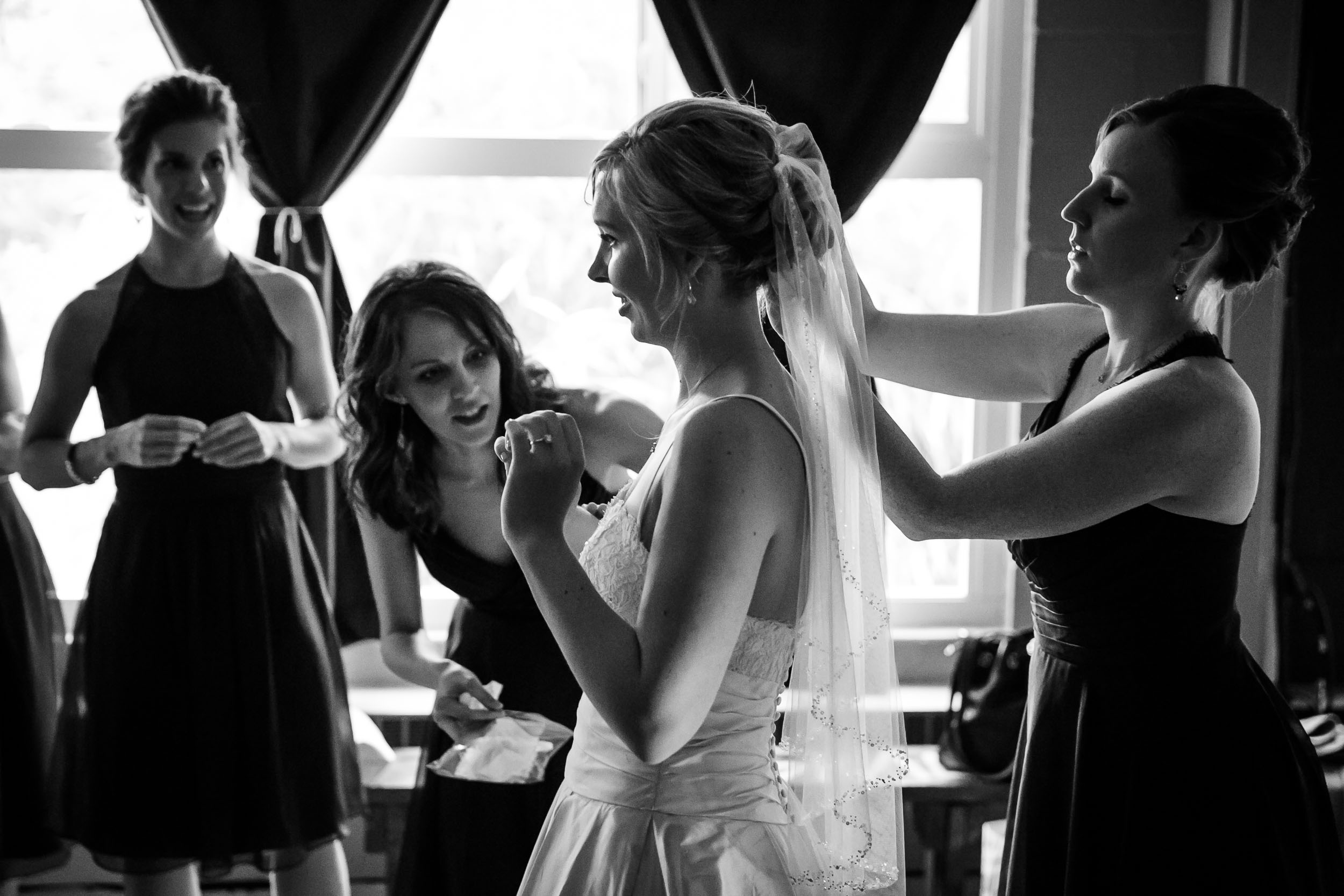 Seattle Community Church Wedding Photography | By G. Lin Photography | Gorgeous shot of bridesmaid pinning veil on bride