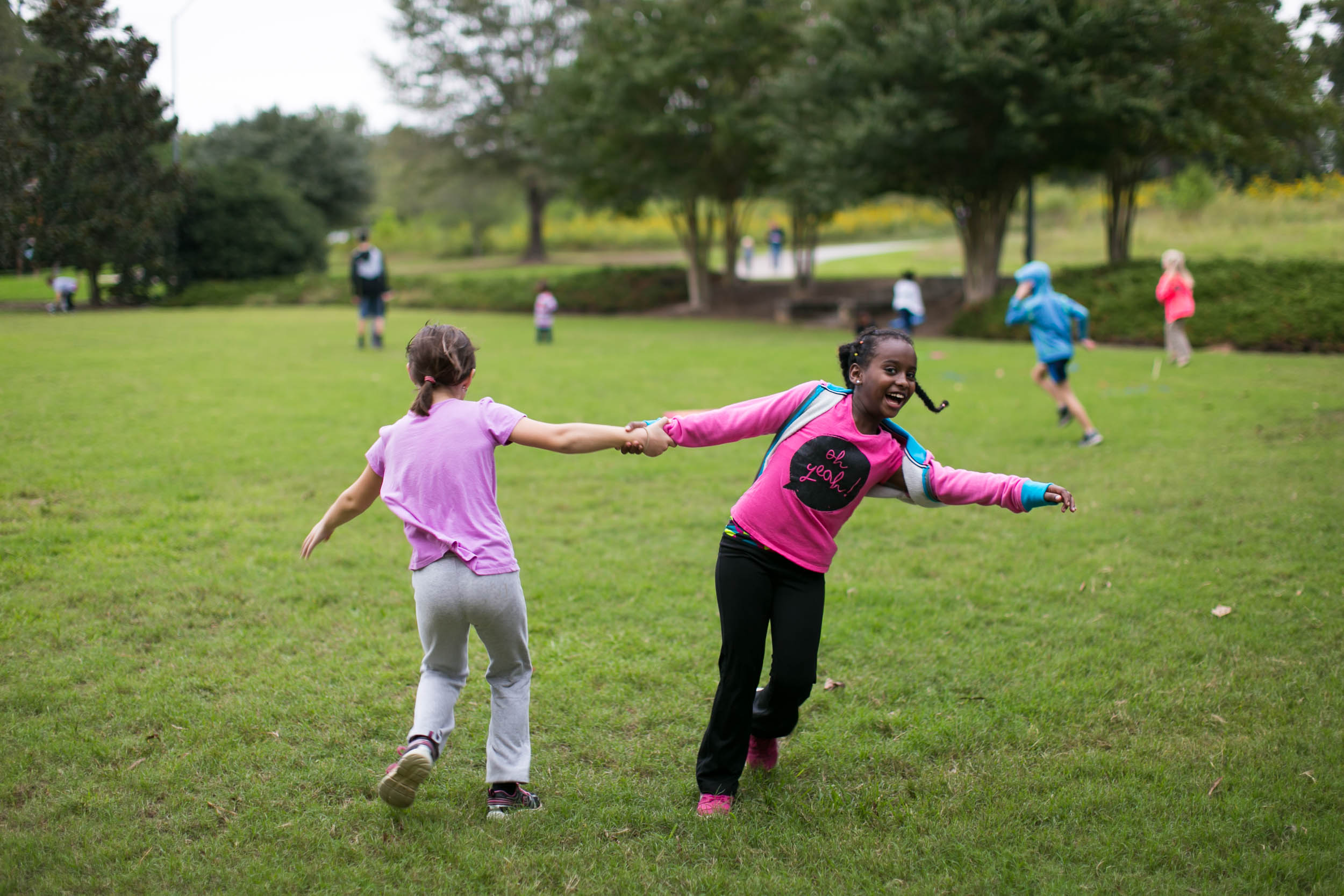 Raleigh Family Photographer | G. Lin Photography | Girls holding hands and running around in park