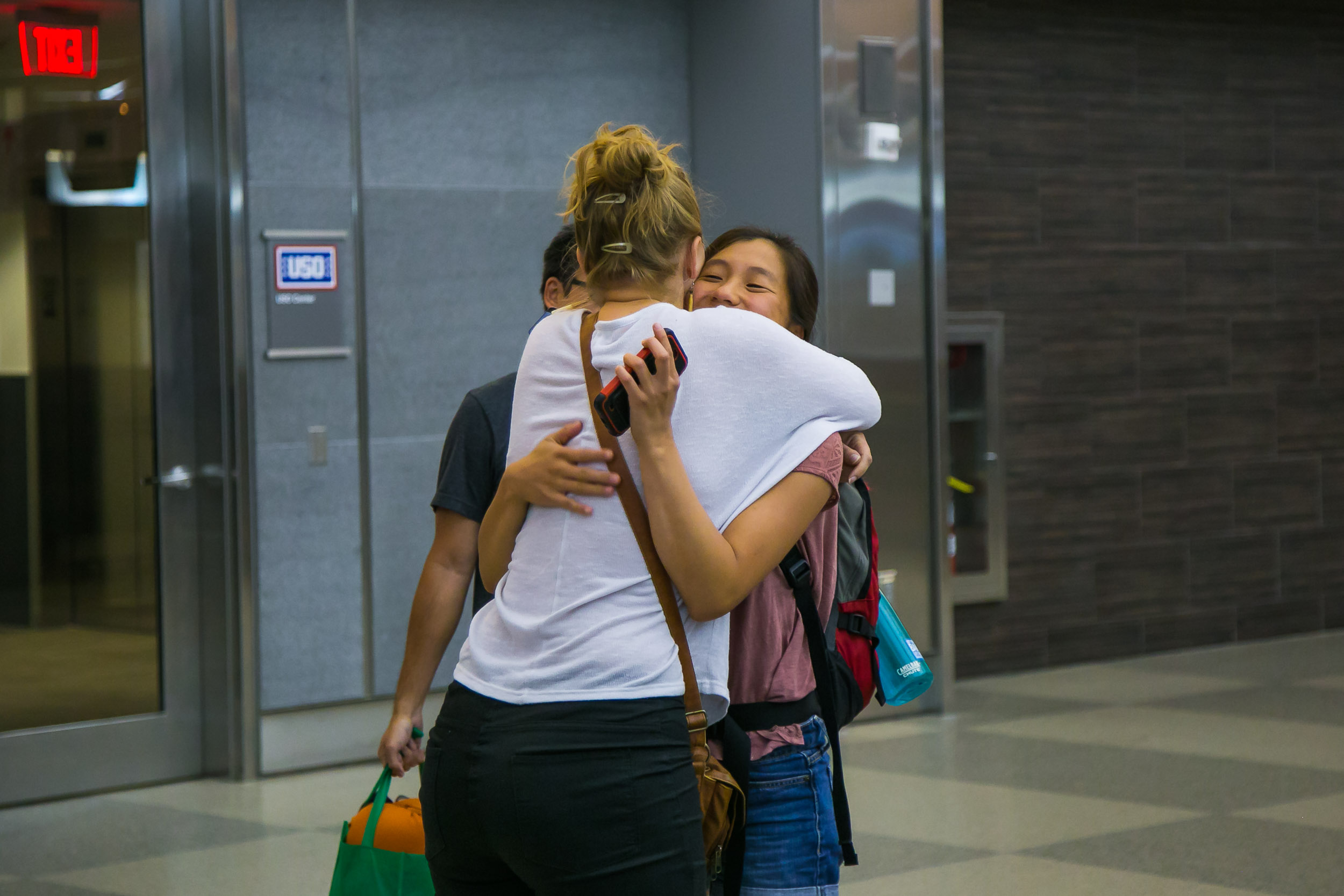 Raleigh Engagement Photographer | G. Lin Photography | Woman hugging friend at airport