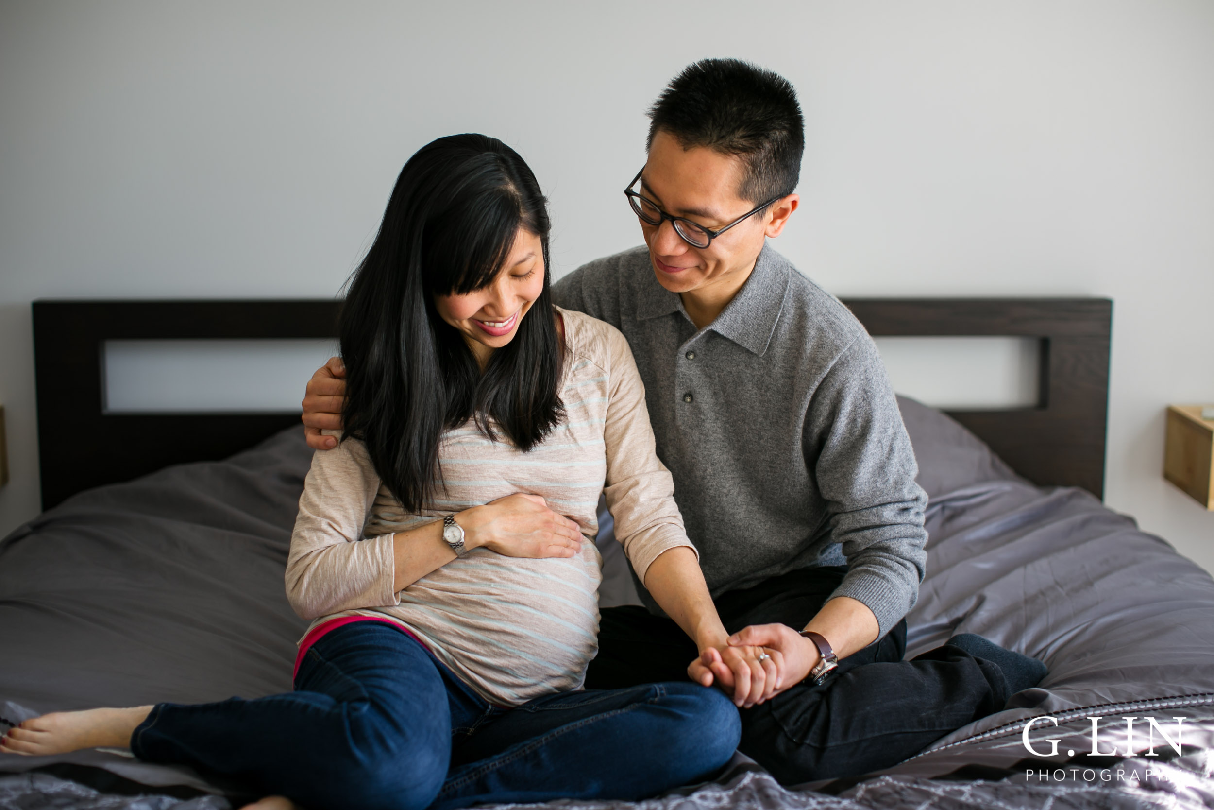 Durham Maternity Photography | G. Lin Photography | Couple sitting on bed and holding baby bump