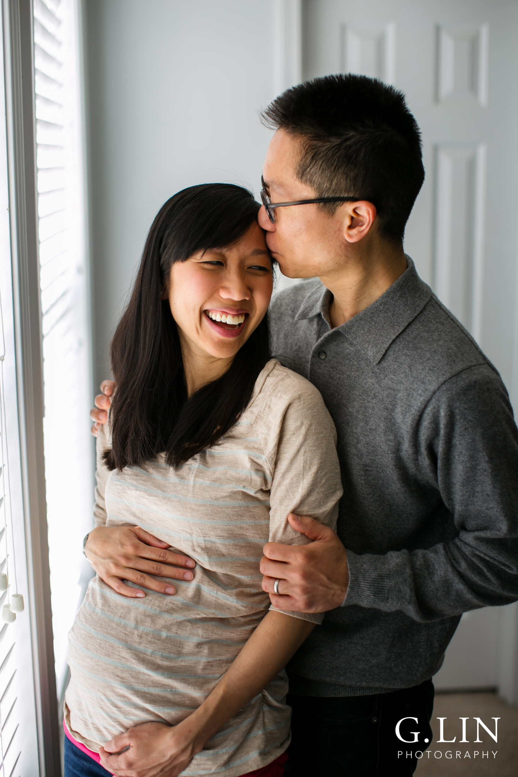 Durham Maternity Photography | G. Lin Photography | Couple standing by window and laughing