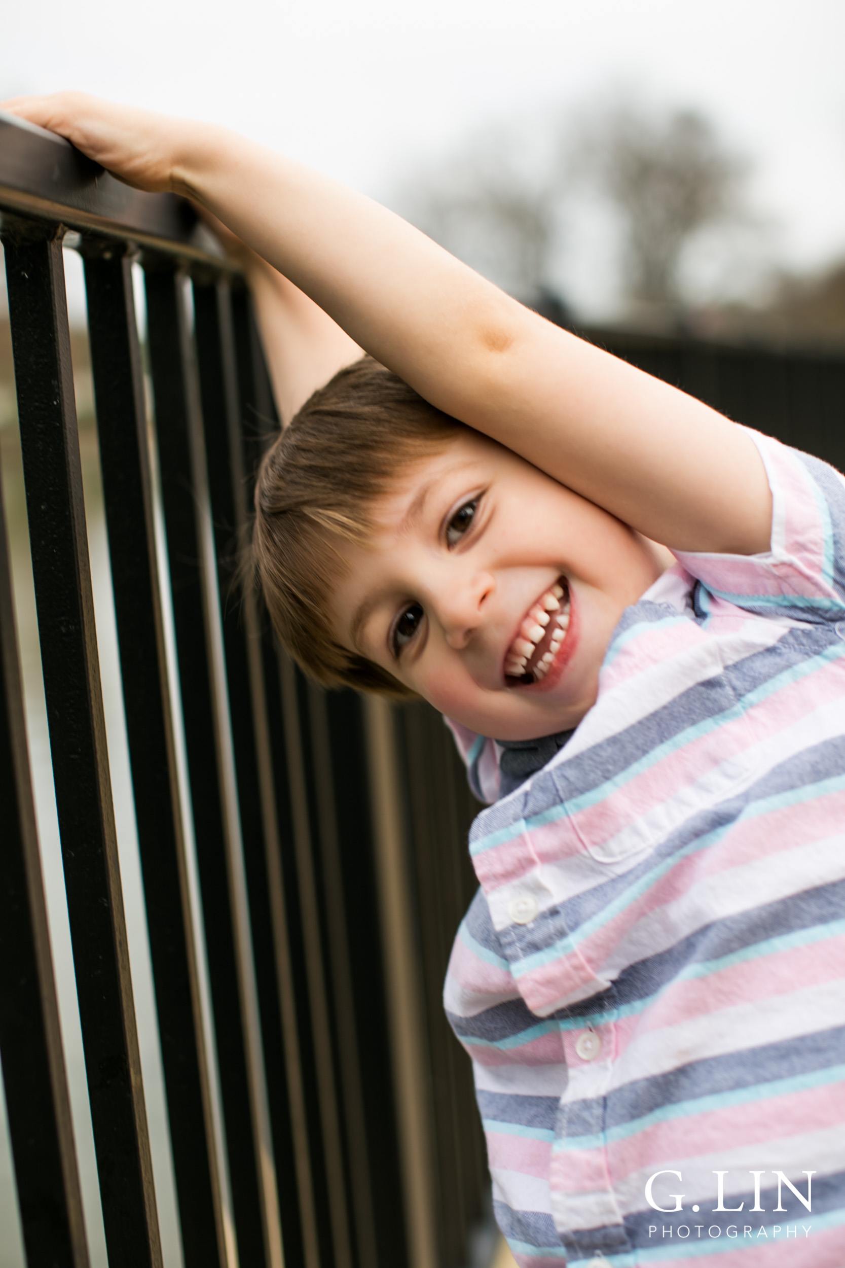 Raleigh Family Photographer | G. Lin Photography | Boy next to fence and smiling