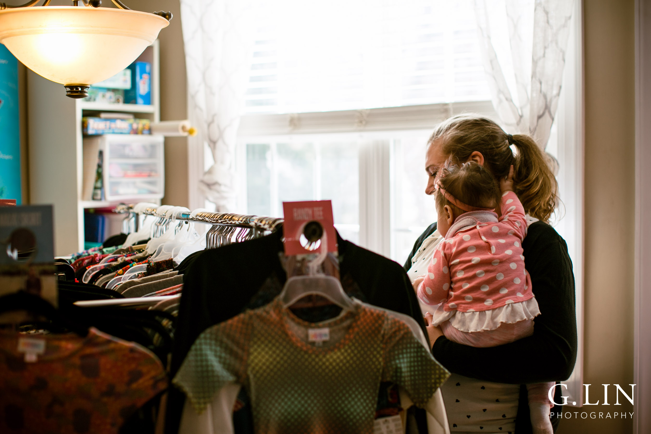 Raleigh Event Photographer | G. Lin Photography | Woman holding baby while browsing at clothes