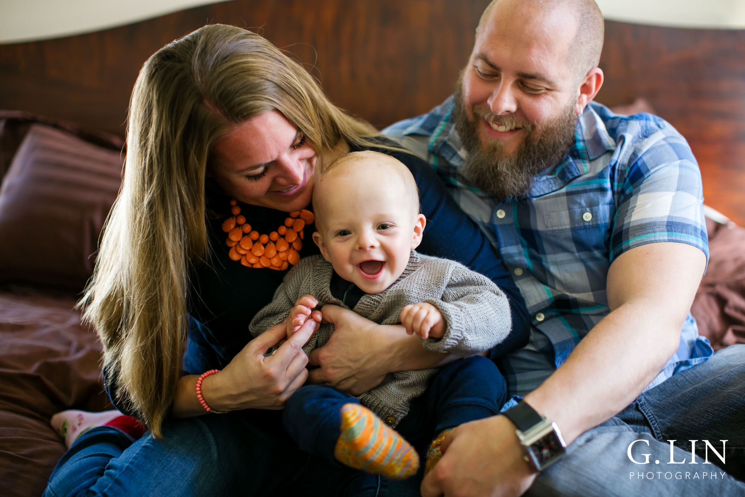 baby laughing while parents are holding child in raleigh