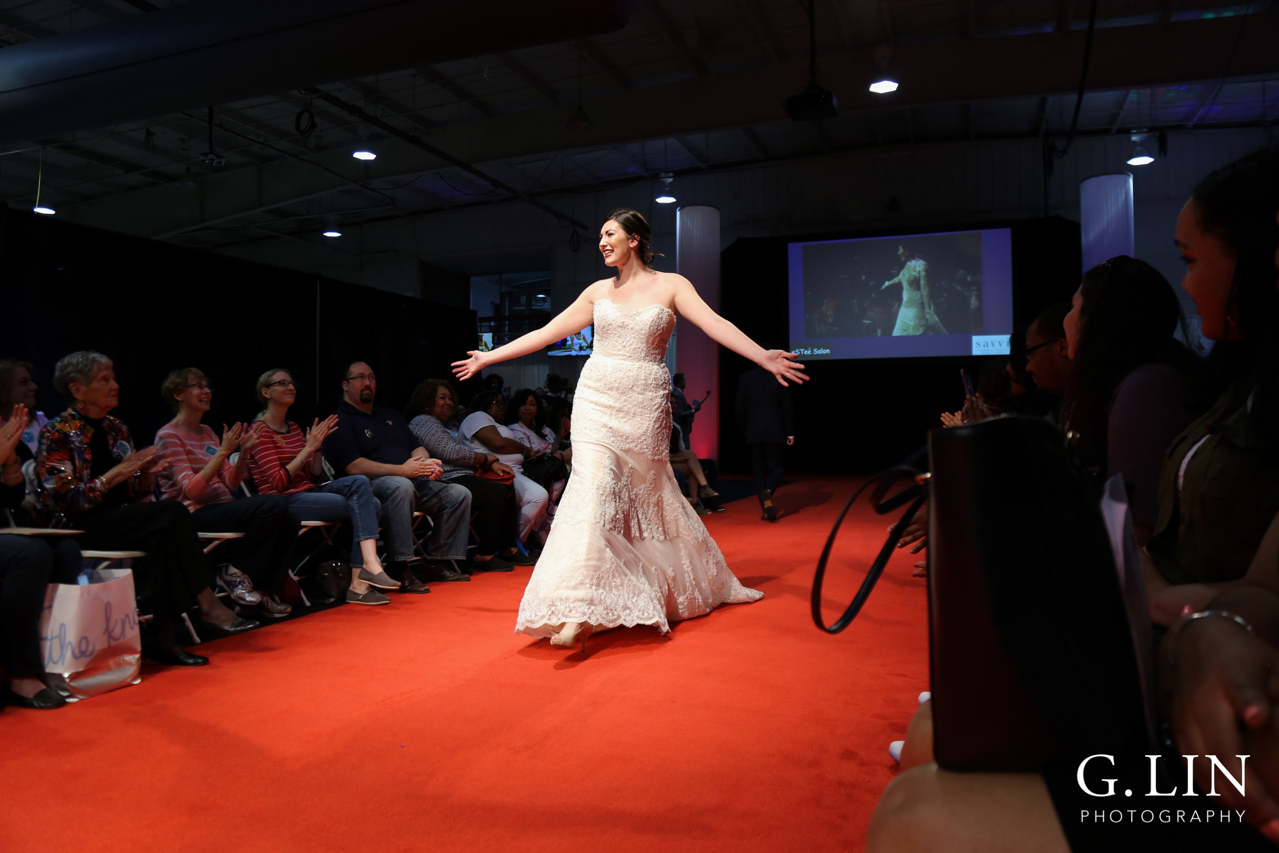 Raleigh Event Photographer | G. Lin Photography | Female model walking down runway wearing strapless bridal gown