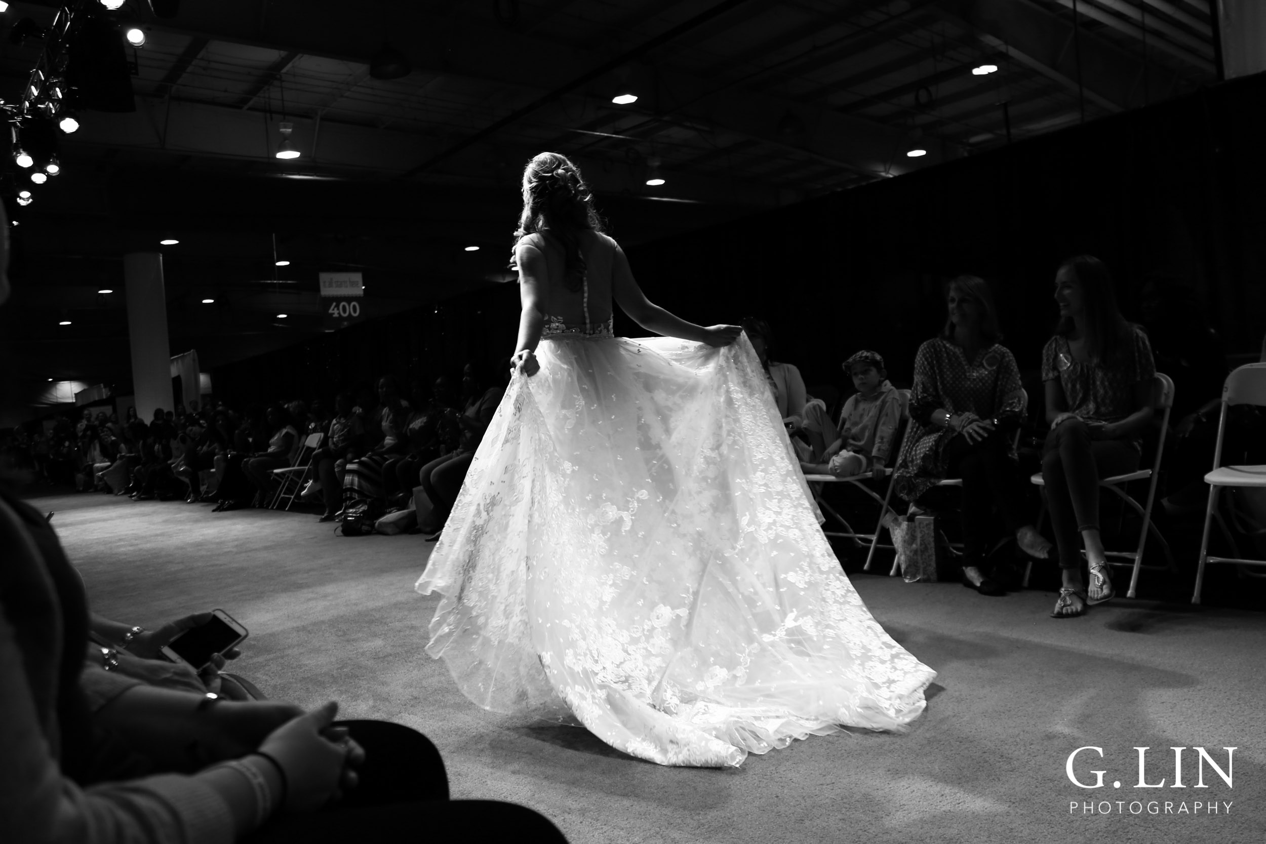 Raleigh Event Photographer | G. Lin Photography | Black and white photo of model walking down runway holding dress