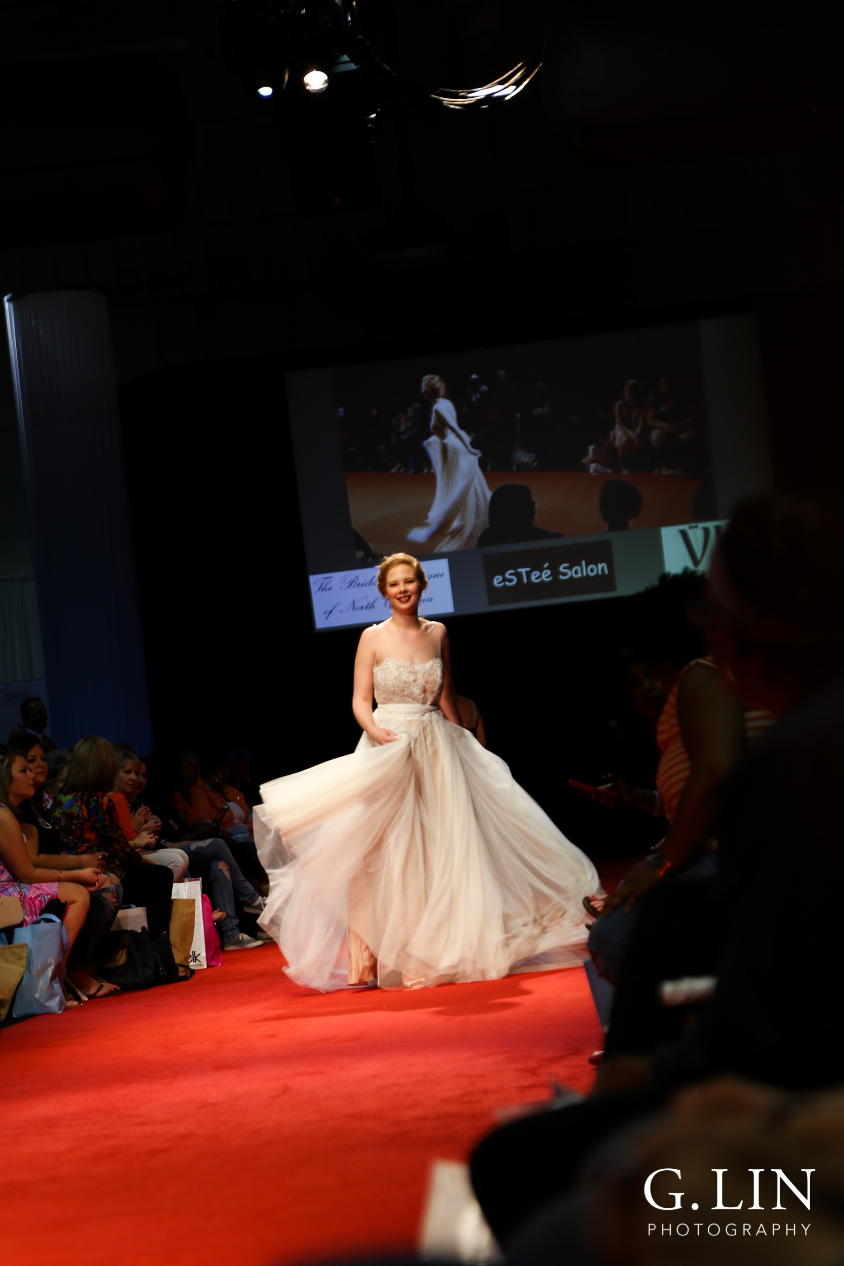 Raleigh Event Photographer | G. Lin Photography | Female model waving wedding dress during fashion show