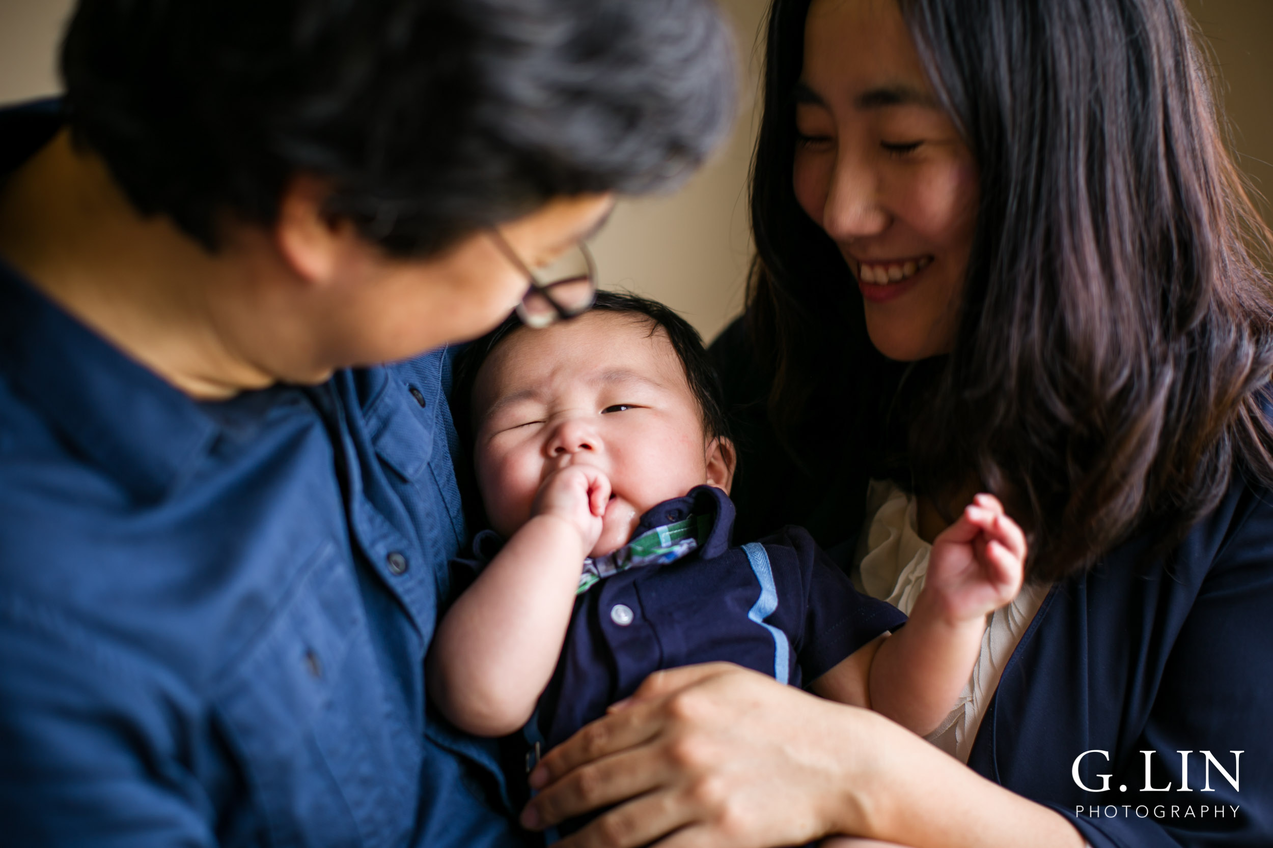 Durham Family Photographer | G. Lin Photography | Parents holding baby at home in bedroom