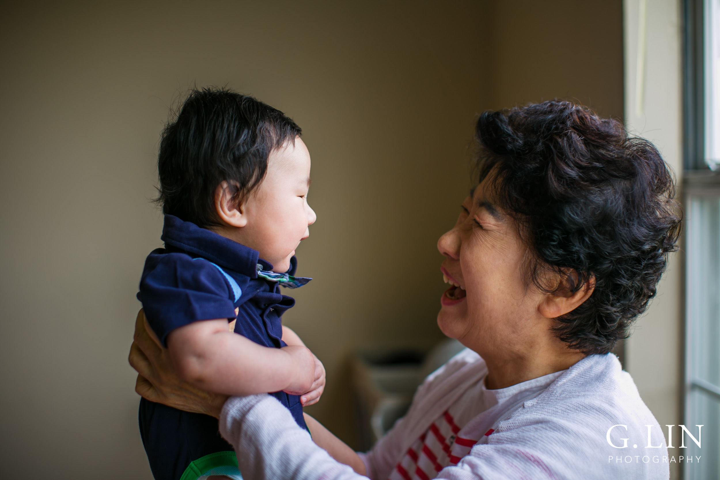 Durham Family Photographer | G. Lin Photography | Grandma holding baby next to window