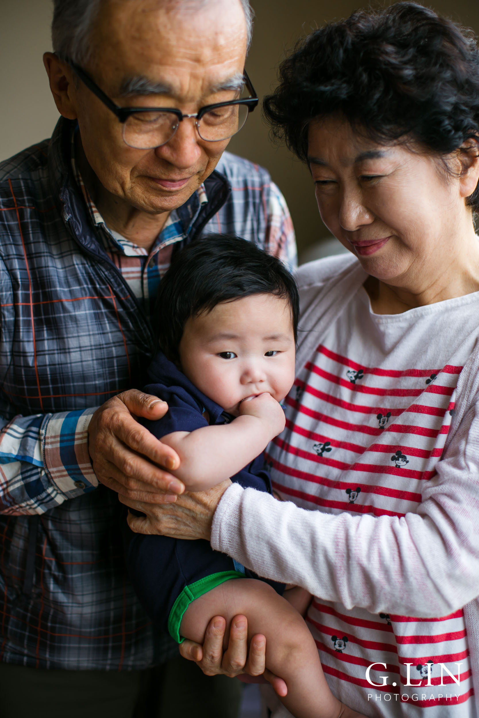 Durham Family Photographer | G. Lin Photography | Grandparents at home holding baby