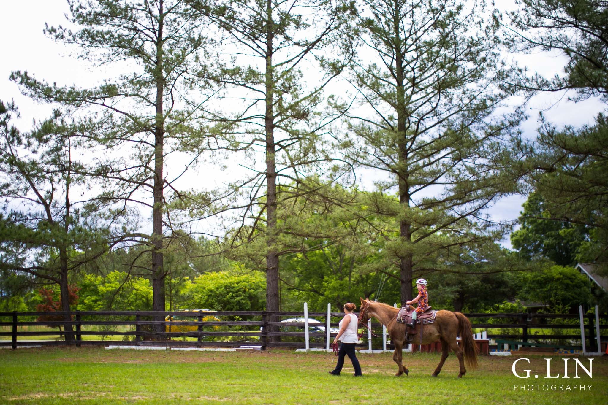 G. Lin Photography | Raleigh Event Photographer | Trainer leading girl and horse around the field