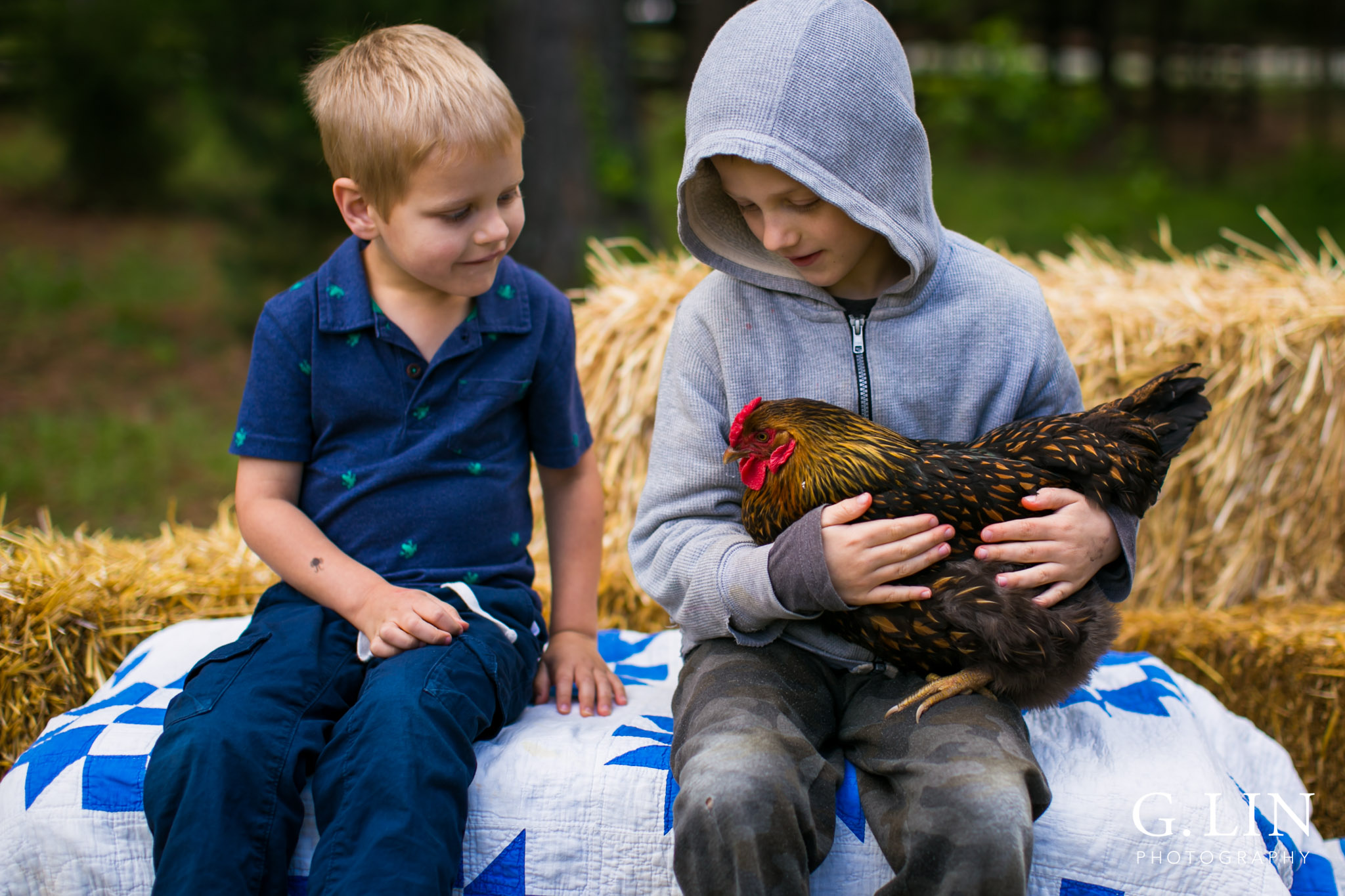 G. Lin Photography | Raleigh Event Photographer | Two boys on hay stack holding chicken